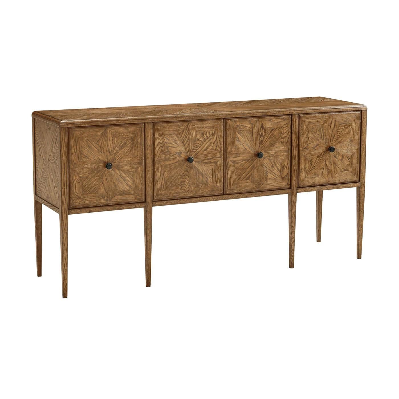 A rustic-style oak four-door buffet with radial star-patterned veneer. Its mosaic-inspired doors are accented with Verde Bronze finish hardware.
Shown in Dawn Finish
Dimensions
68.5
