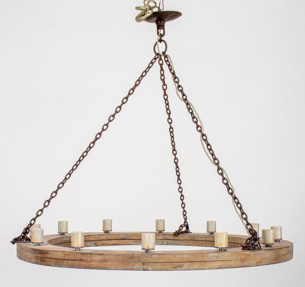 Rustic cerused oak and patinated iron chain twelve-light wheel form chandelier. 

Dealer: S138XX