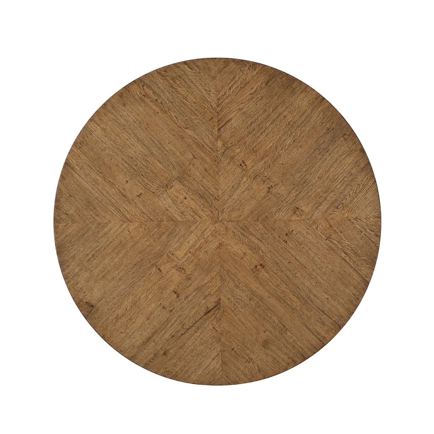 A rustic oak parquetry round dining table with column pyramid base. This elegant table is detailed with a herringbone oak parquetry base and radial veneered top. It has been hand-carved and given our Dawn finish.

Shown in dawn finish
Dimensions: