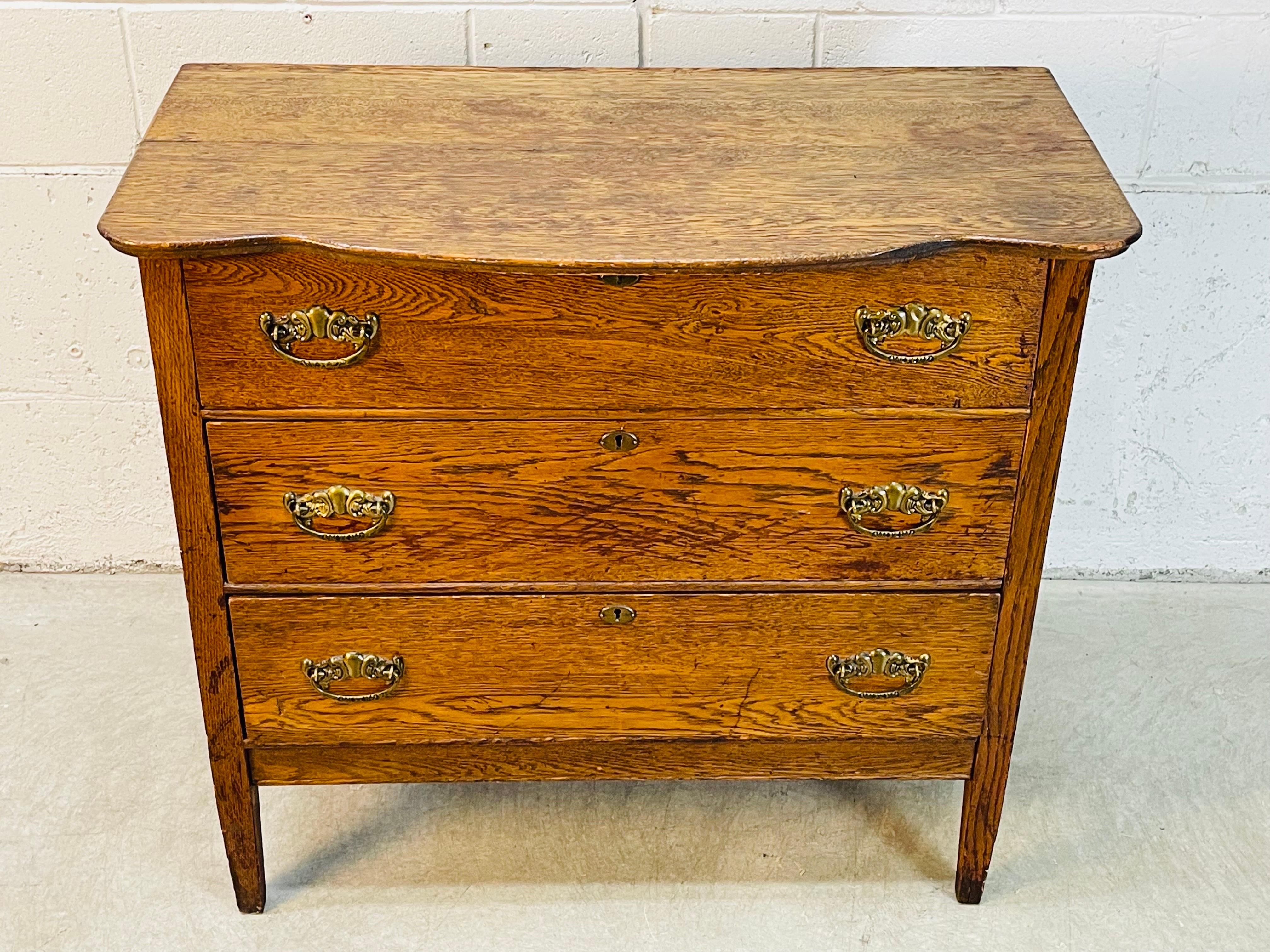 Vintage oak wood three drawer dresser or storage cabinet. The drawer pulls are brass and the drawers open and close freely. Was refinished a long time ago and has a nice aged patina. Drawers are 5-6”H. Cabinet is sturdy. No marks.