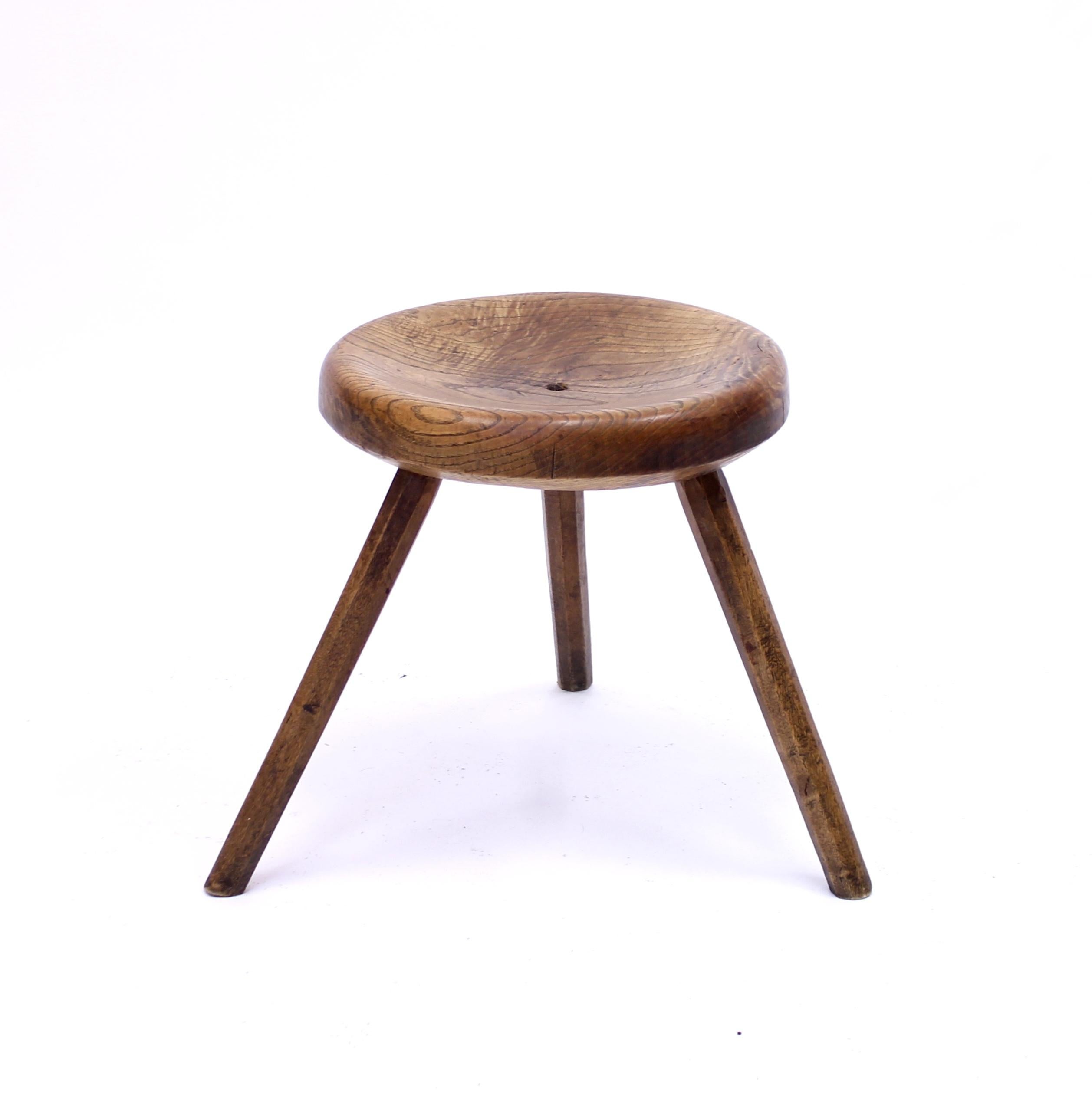 Rustic oak work stool from the mid 20th century featuring three octagonal legs and a round lathed seat. Charming and quite roughly made. Good vintage condition with light ware consistent with age and use.