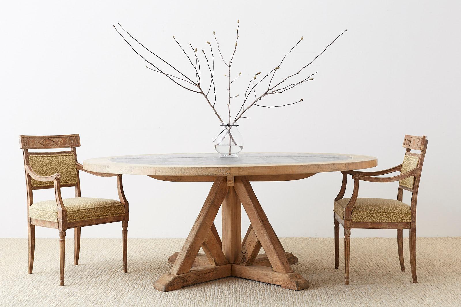 Massive rustic oak round dining table featuring a zinc top with a blonde hardwood surround. Bespoke handcrafted table with a cross base pedestal having a weathered finish. Constructed from thick reclaimed oak timbers made with old world peg joinery.