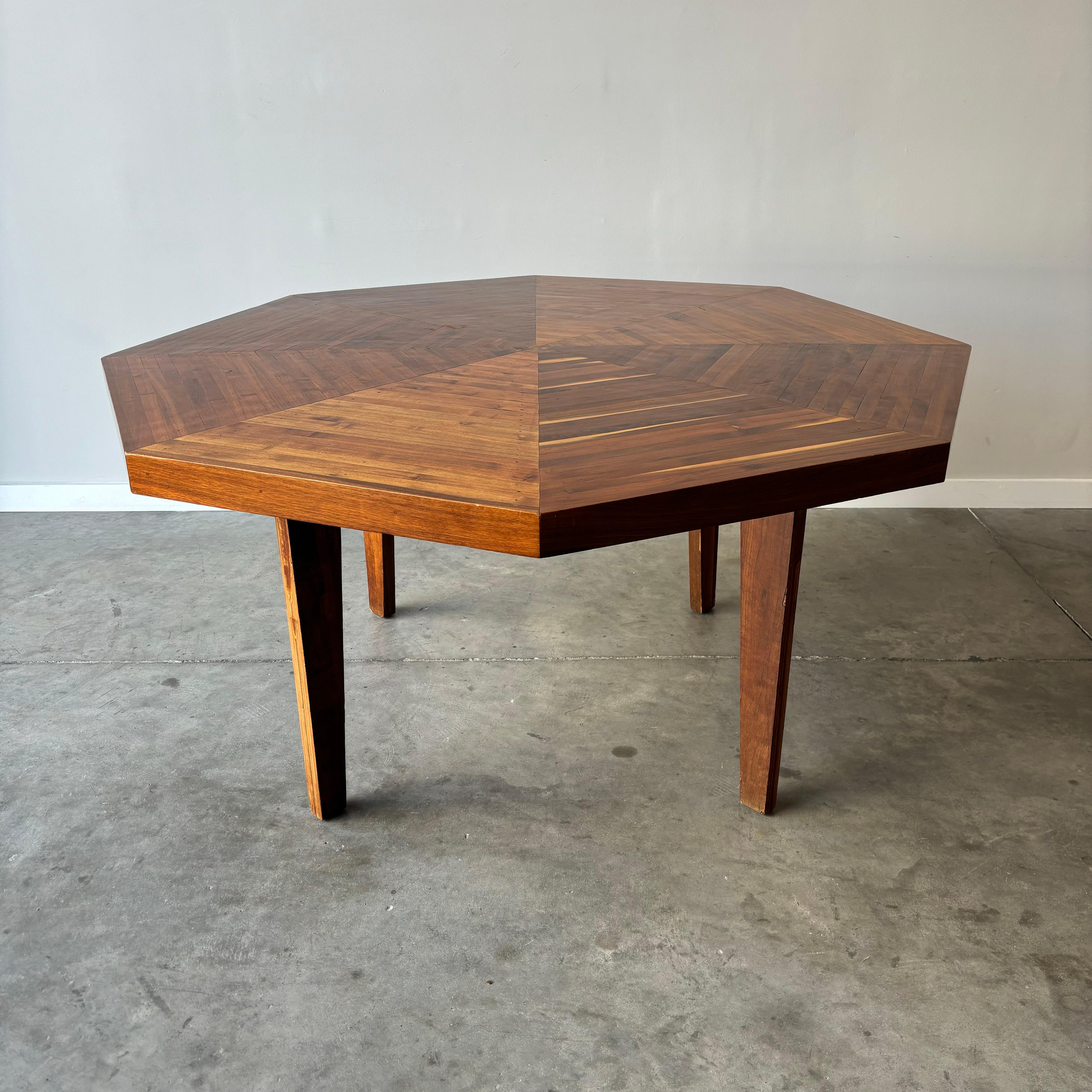 A vintage handmade walnut dining table.  The rustic hand-crafted nature of this piece is its defining characteristic.  Worn and chipped veneer legs with rough sanded and hammered nailed wood slat top, polyurethane finish.  Measures 61