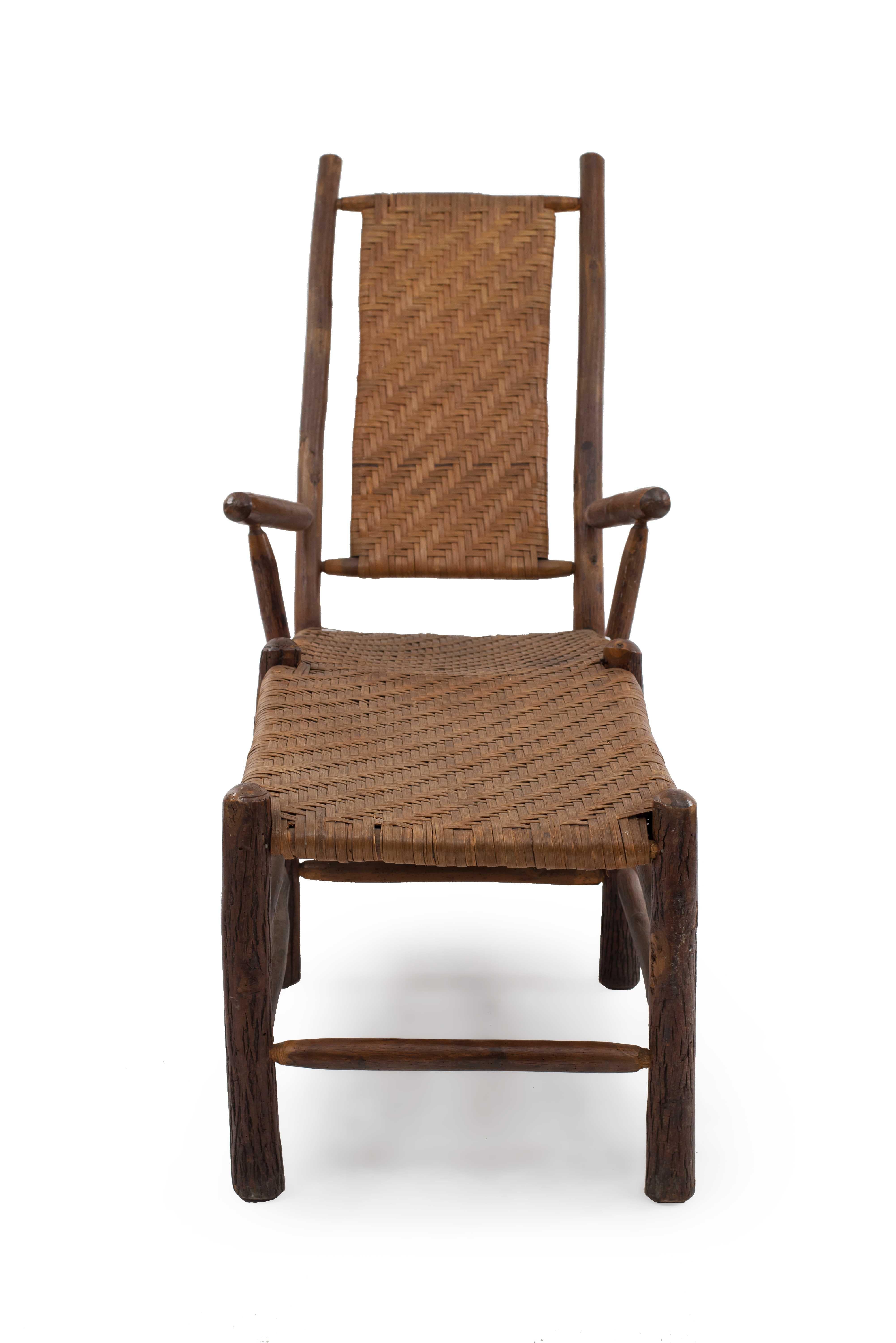 Chaise longue rustique en Old Hickory (Circa 1930s) avec siège en rotin sur des pieds joints par un châssis en caisson. (Marque : Rustic Hickory/ Furniture Co/ Laporte Ind)
