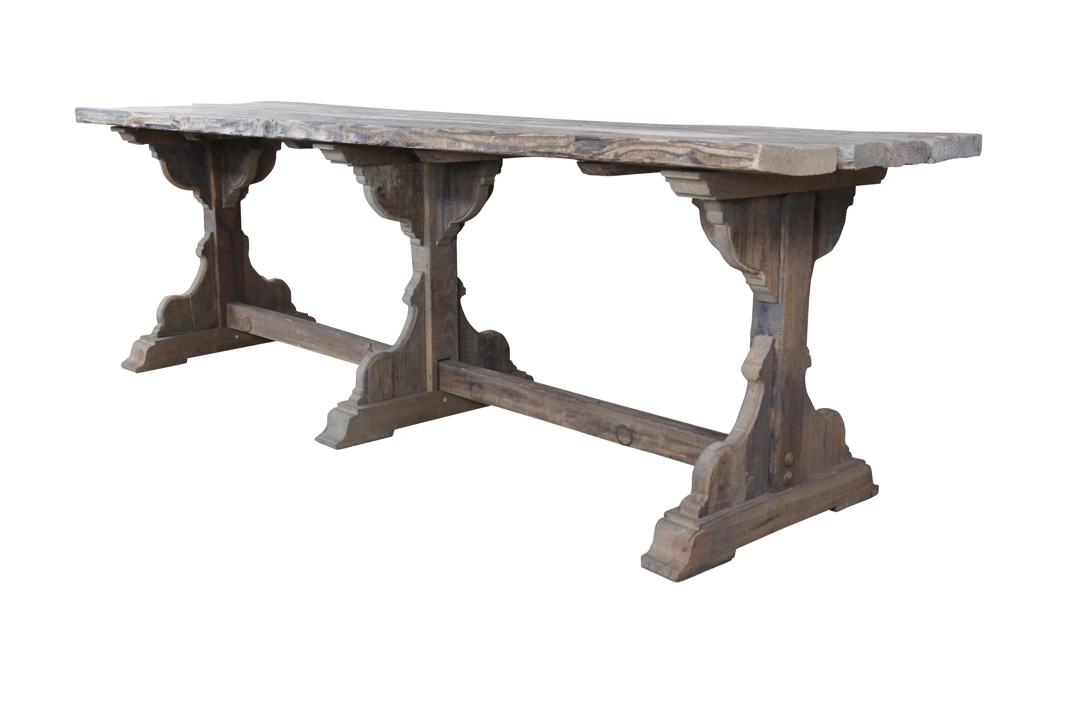 An impressive European refectory / dining table. Constructed from antique pine. Features a rustic patina with a three board top over trestle base.