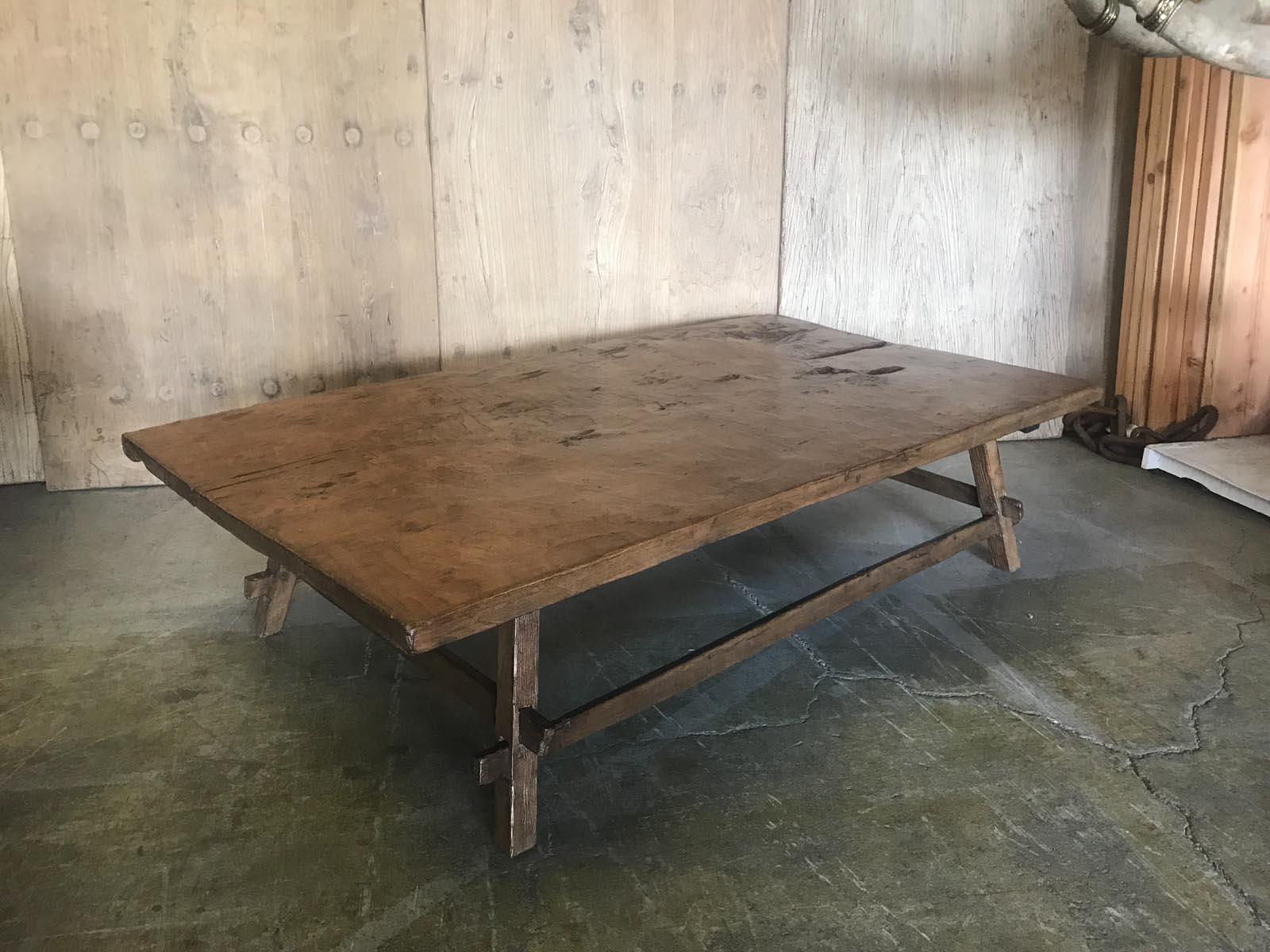This coffee table consists of an antique one wide board. It is hand hewn and shows age appropriate wear. The top is slightly warped but it does not take away from its functionality. The base is contemporary and finished to match the top. Great