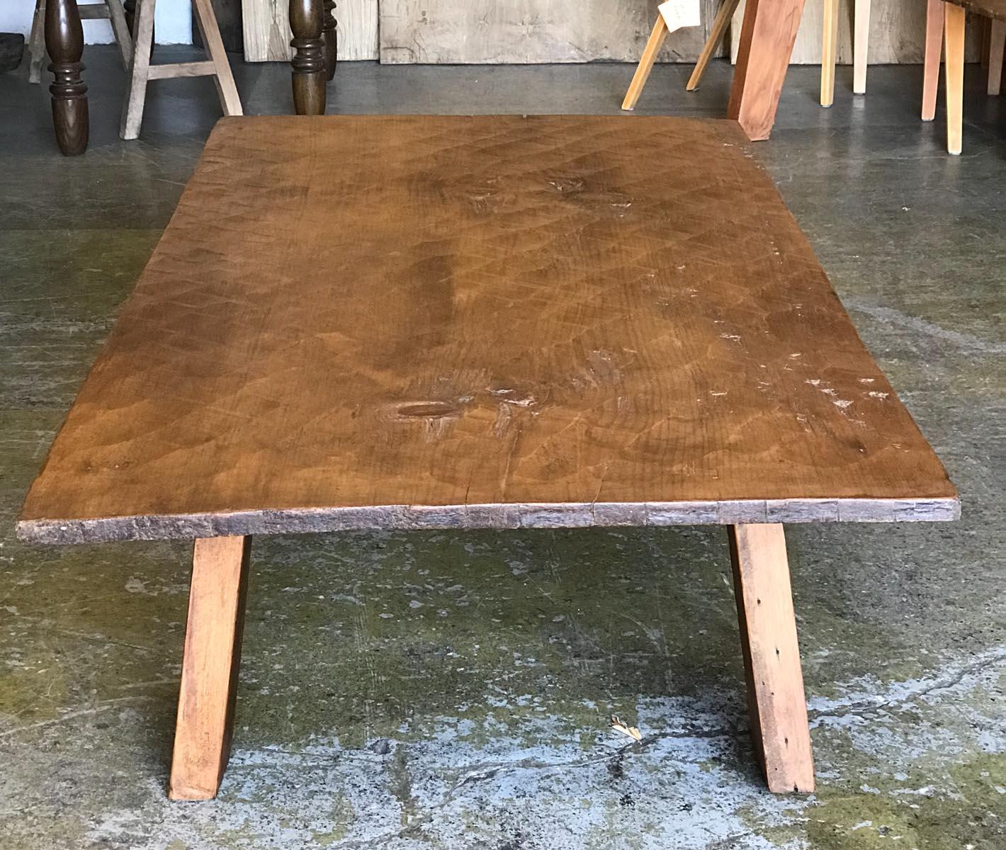 This coffee table is made with a 19th century, one wide board top and reclaimed wood legs. The top  was hand hewn and shows the workmanship of the machete. Beautiful patina. Wax finish. Great rustic, sturdy piece.