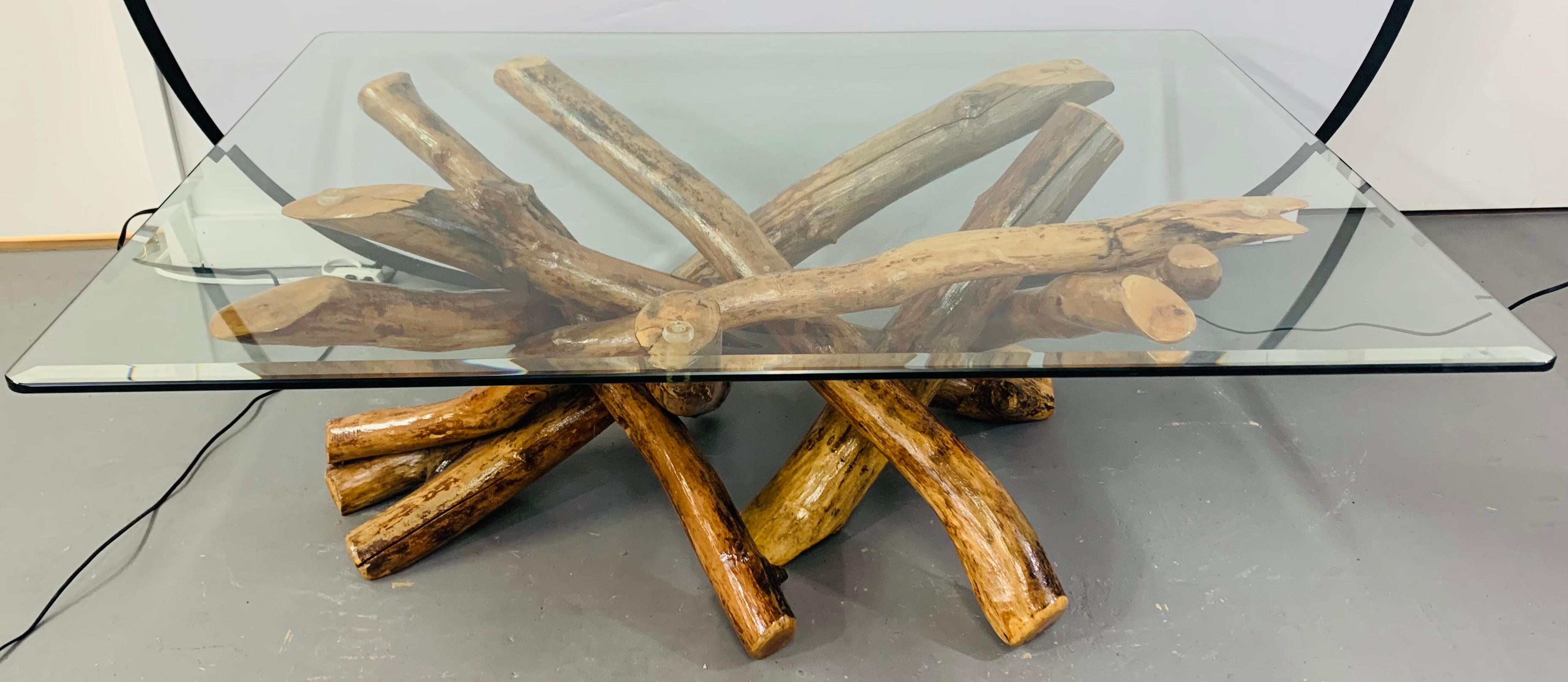 A rustic natural wood base coffee or cocktail table in an organic design fashion. This amazing table features veneered maple wood twist logs put together in an intertwining manner to present an artistic wood sculpture as the table base and a heavy