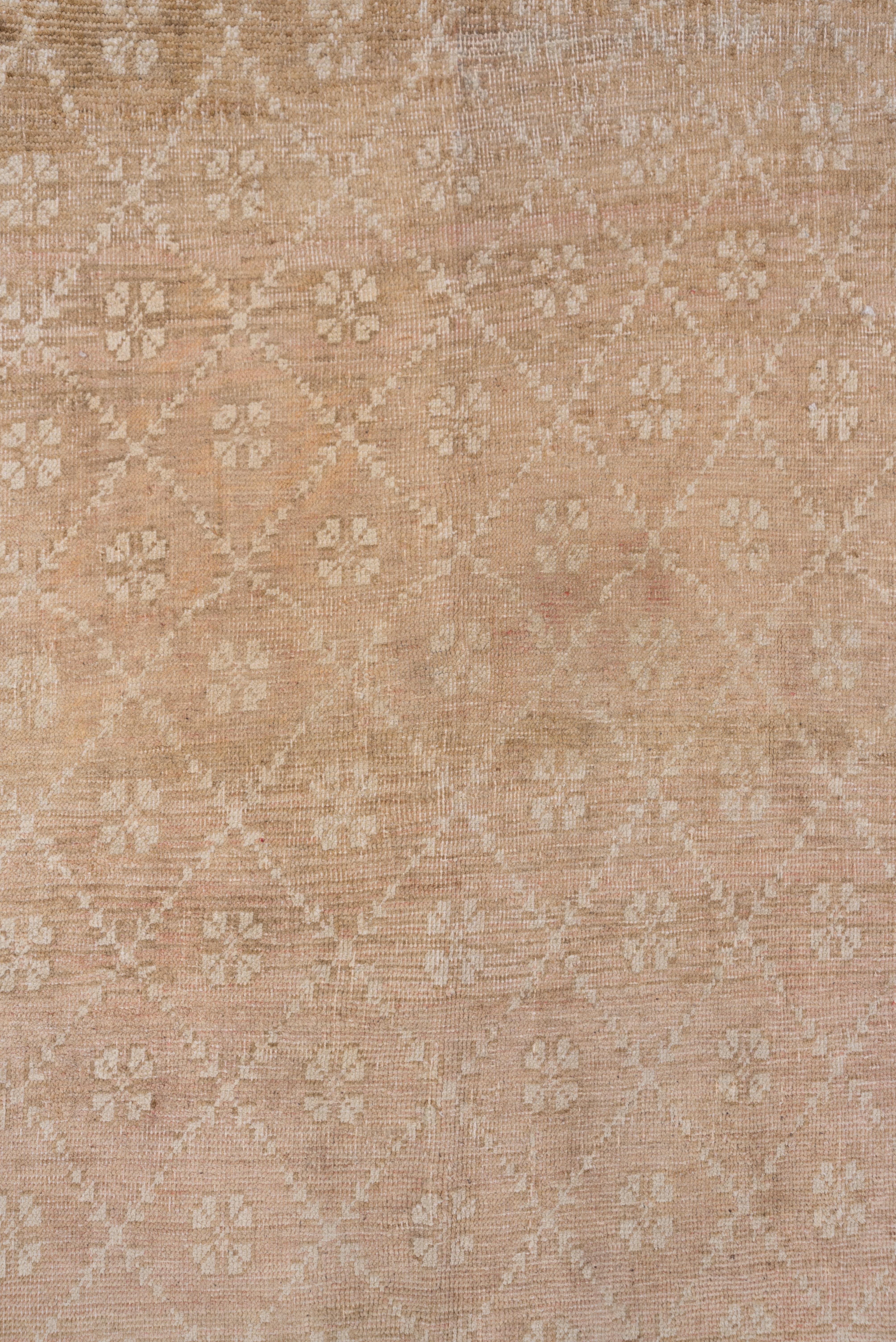 This plain border large Turkish rustic scatter shows a simple lozenge leaf lattice in sand enclosing sand rosettes on a buff-beige ground.