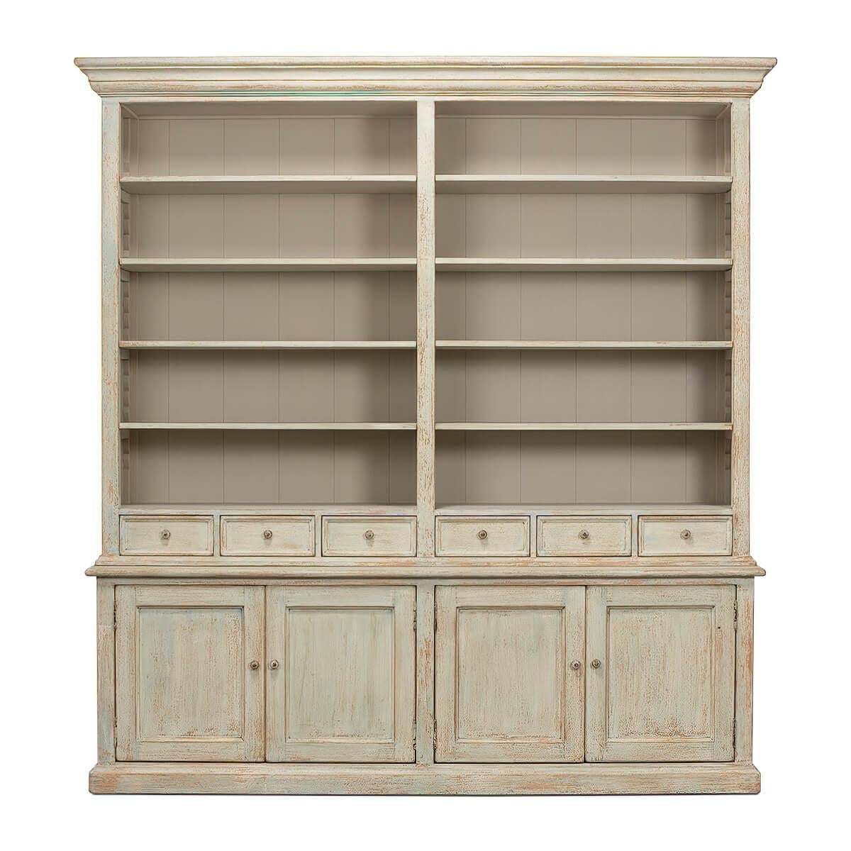 Traditional style Rustic painted bookcase with soft antique blue wash painted finish on reclaimed pine. With a molded cornice, adjustable shelves, six mid drawers and four cabinet doors below raised on a square plinth base.

Dimensions: 93