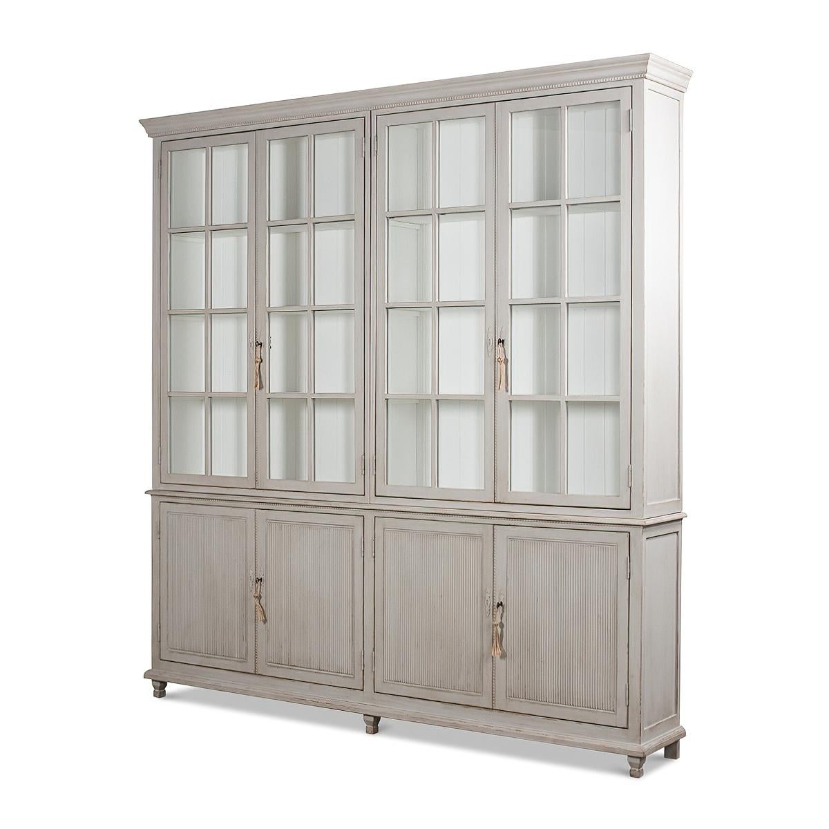 A Transitional Rustic grey painted bookcase with a distressed finish. The upper section with four glass door display sections and a molded cornice. The lower section with reeded panel doors. With decorative antique-style locks.

Dimensions: 97