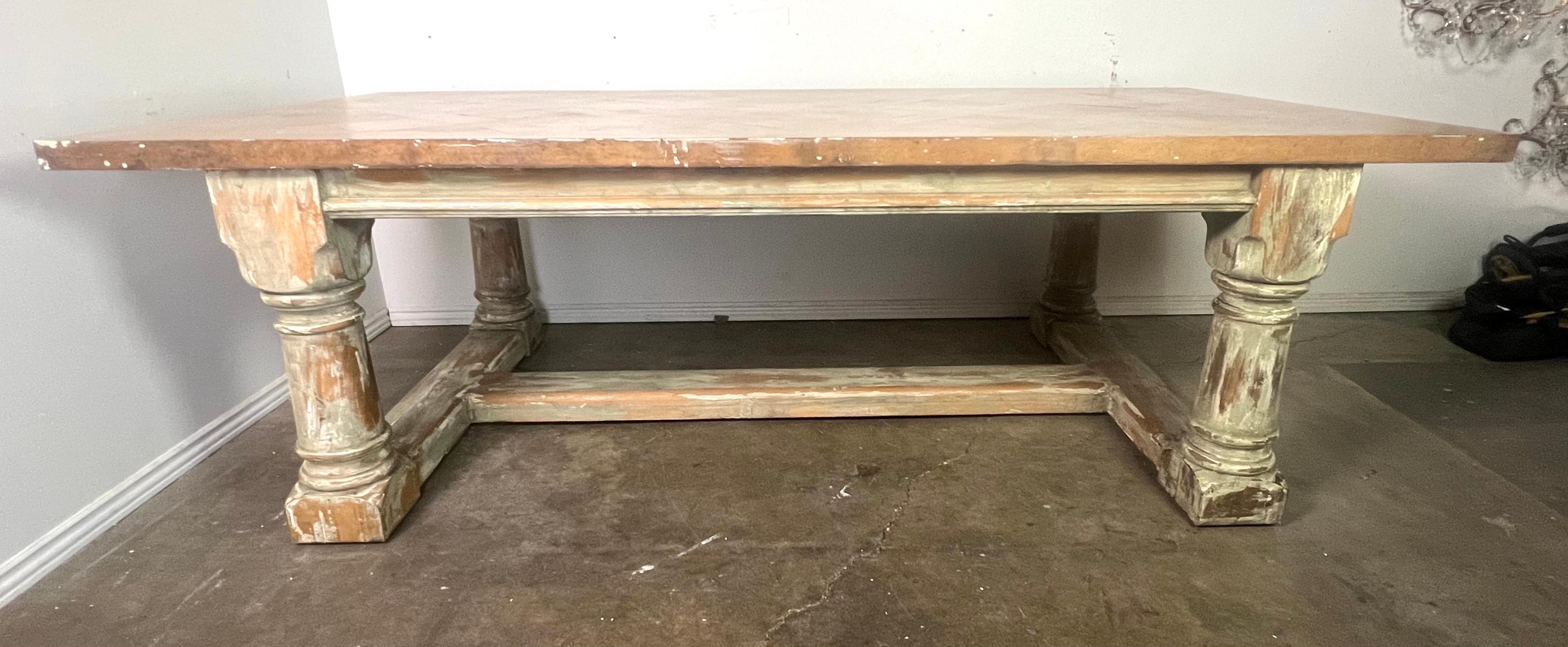 Rustic vintage dining table with a sturdy and traditional design.  The top has a unique herringbone pattern in a light wood finish.  The herringbone pattern adds texture and visual interest to the surface of the table top.  The edges show wear,