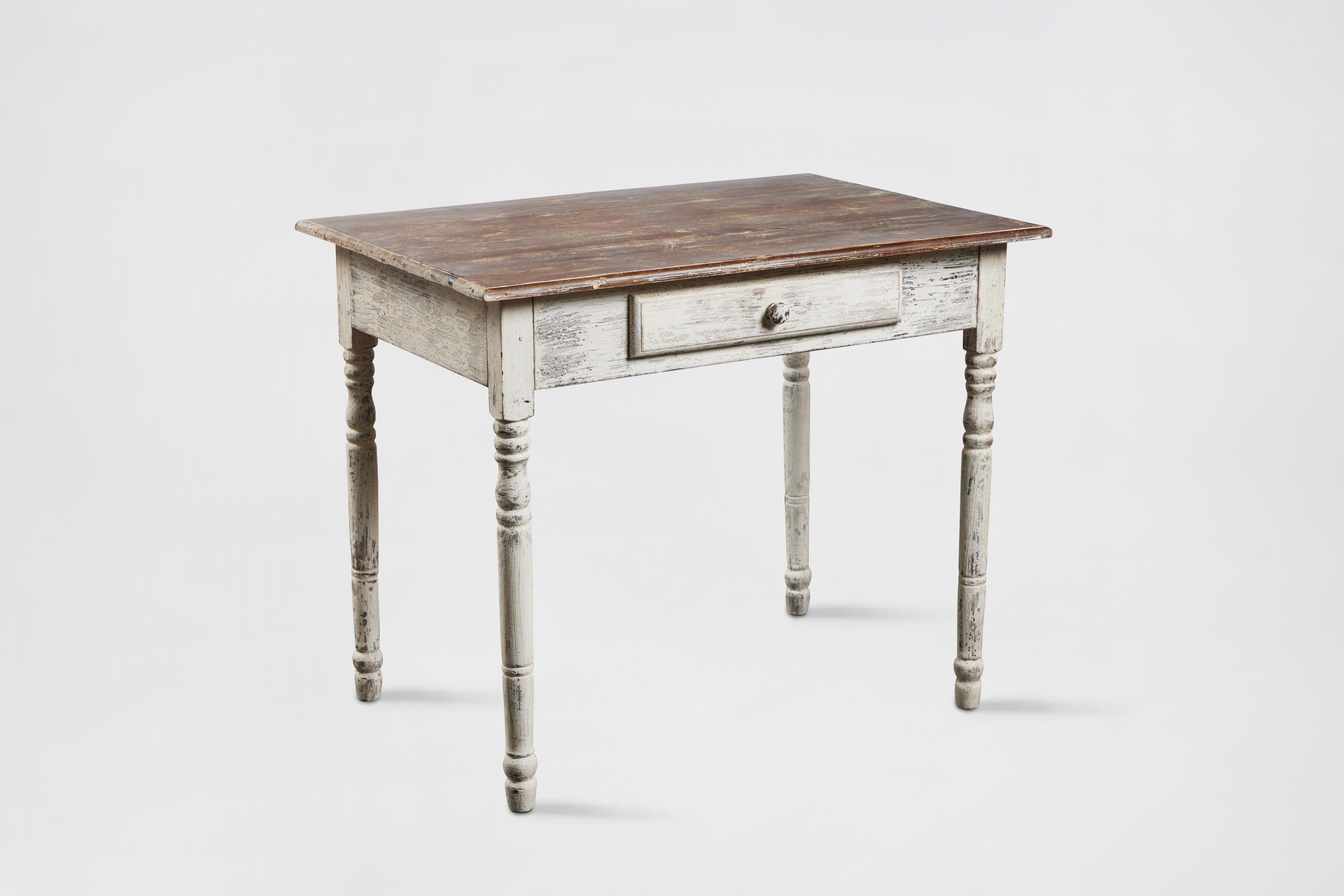 Rustic or farmhouse style wood side table with drawer. White painted carved spindle legs and natural wood top, distressed finished applied. Made by John Hall Designs, Los Angeles, 1995. 
