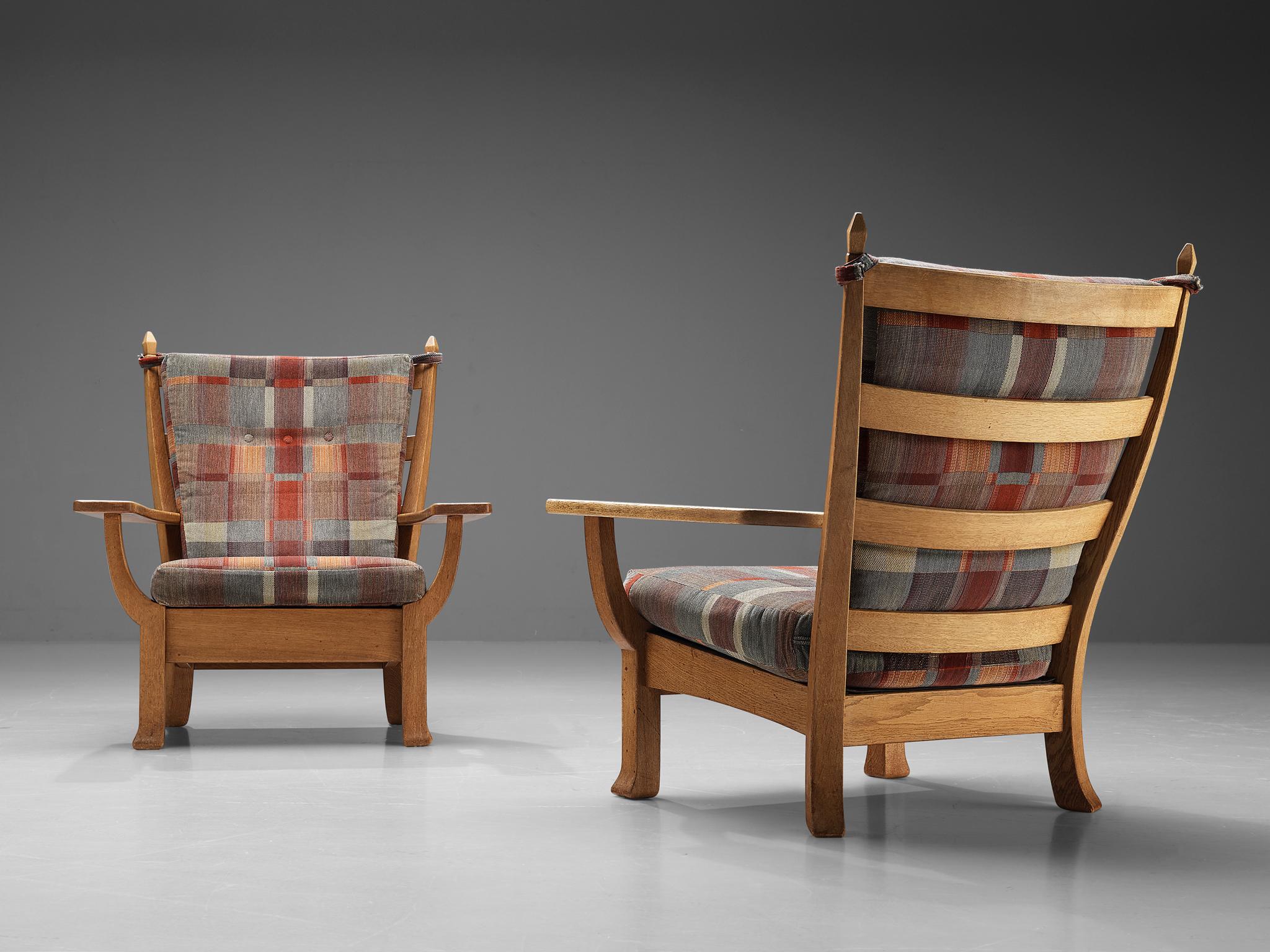 Pair of armchairs, oak, fabric, Europe, 1960s 

These exquisite pair of lounge chairs are well-executed embodying a solid construction. With its imposing, elongated backrest, this design is suitable as either the heart of your interior or its focal