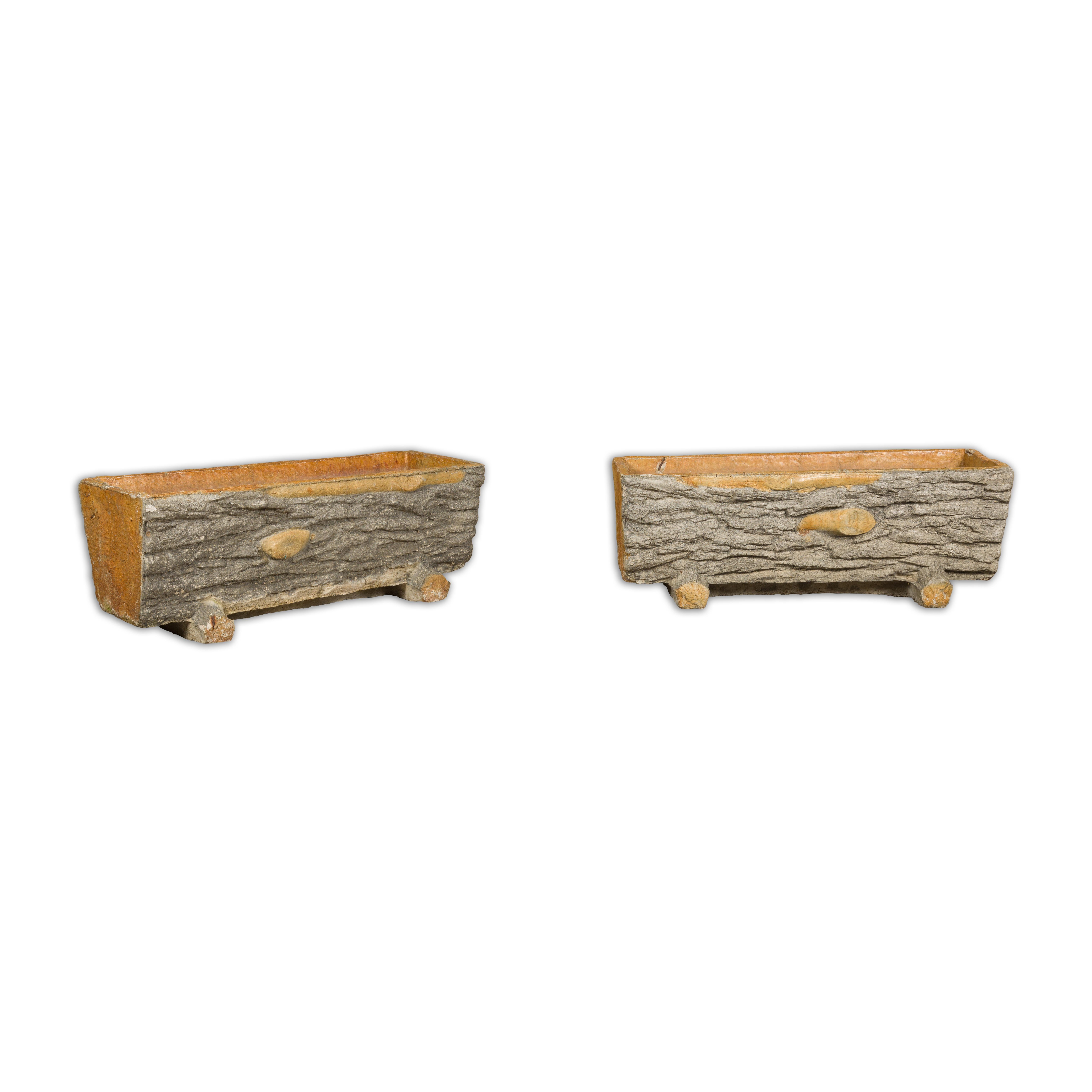 A pair of faux-bois trough shaped planters circa 1930, made of concrete with grey and orange tones. Enhance your outdoor space with this captivating pair of faux-bois trough-shaped planters from the 1930s. These planters are crafted from durable