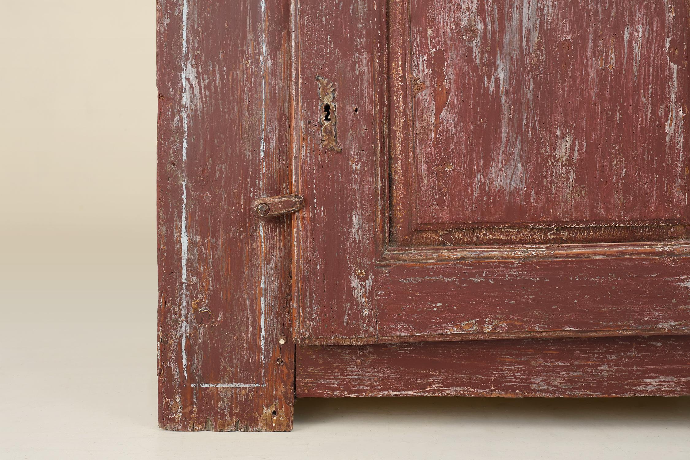 19th Century Rustic Parisian cabinet in pine wood with old burgundy paint layers, ca. 1820 For Sale