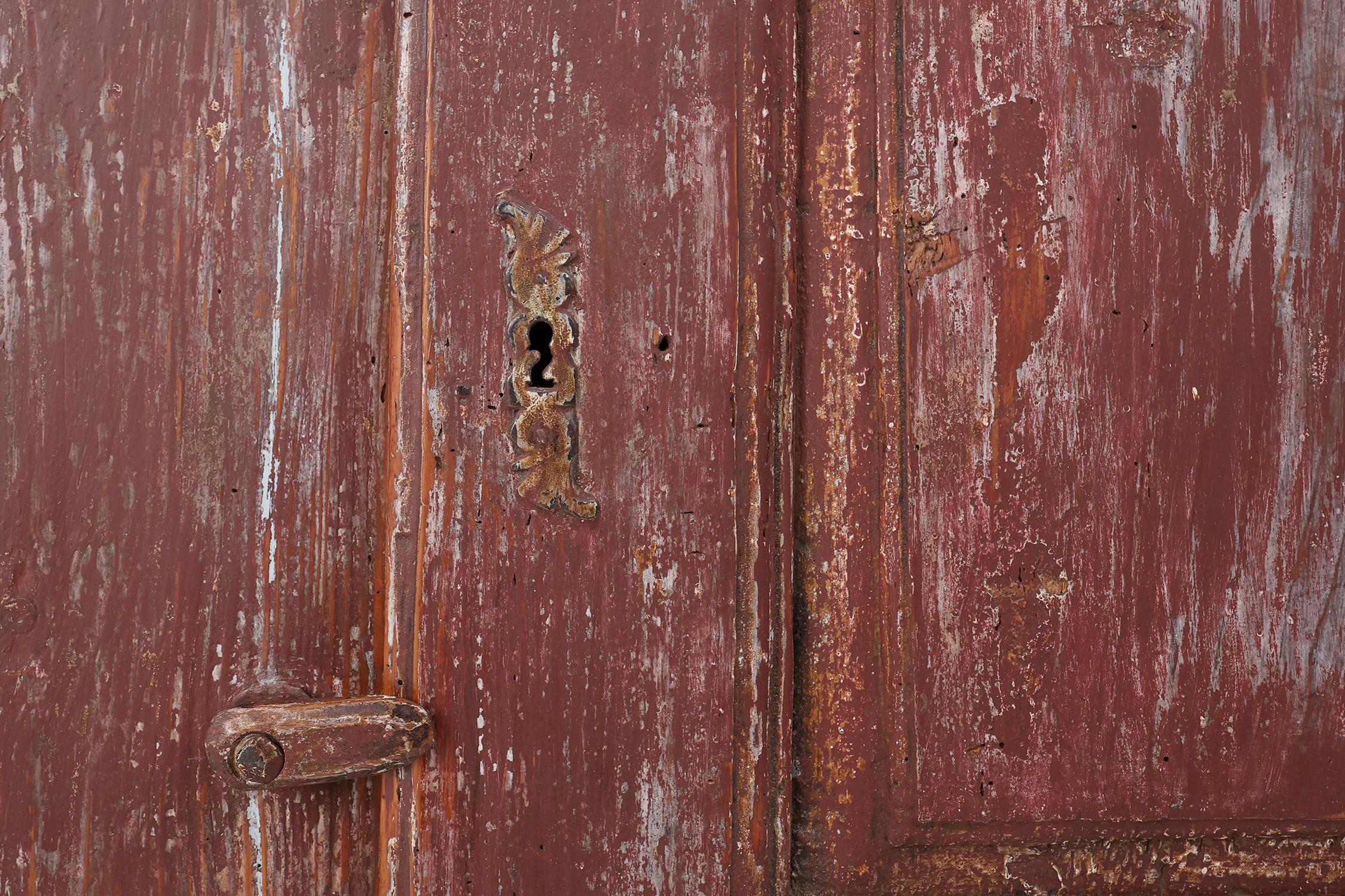 Pine Rustic Parisian cabinet in pine wood with old burgundy paint layers, ca. 1820 For Sale