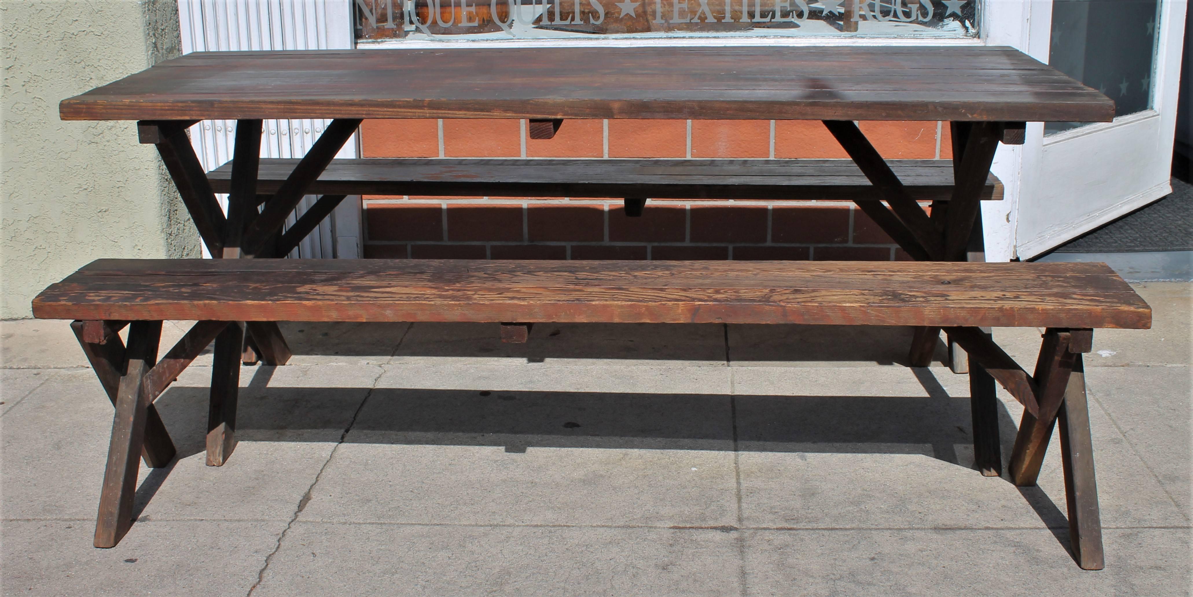 This rustic table measures 70 wide x 27 deep x 27 high. This set was found at a cabin at Big Bear. It has a wonderful worn and mellow patina.
The condition is very strong and sturdy. The aged patina and wear is fantastic.
 The Bench's measures 70