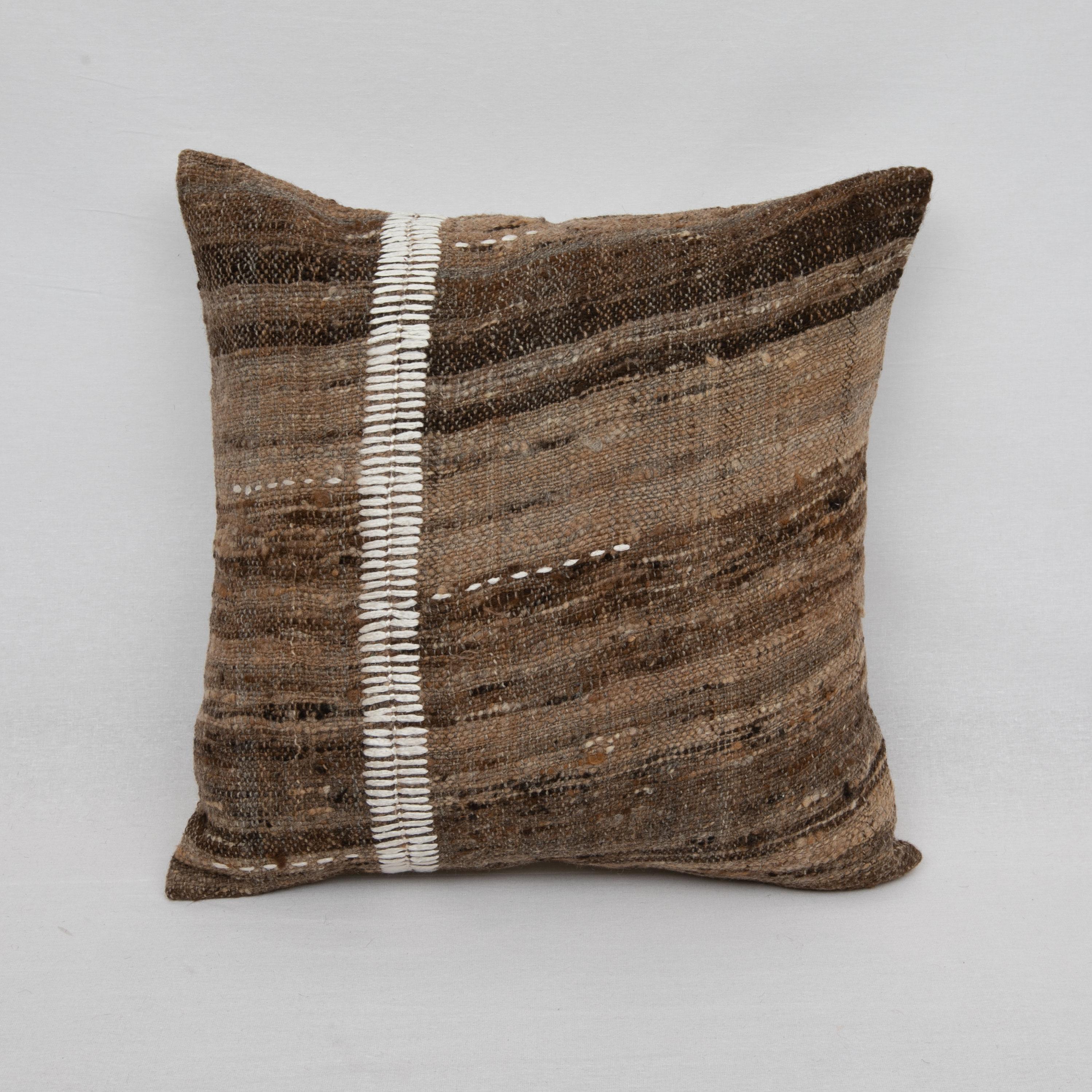 This pillow is made from a vintage coverlet that is hand woven using un-dyed wool.
Our addition to the piece is silk hand stitching.

It does not come with an insert.
Linen in the back.
Zipper closure.
 