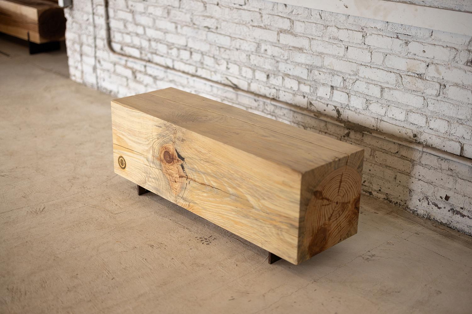 Our beam bench utilizes salvaged local pine logs for a rustic bench for indoors or outdoors. Narrow and backless, the simple lines express the natural texture of the end grain of each species. The 15