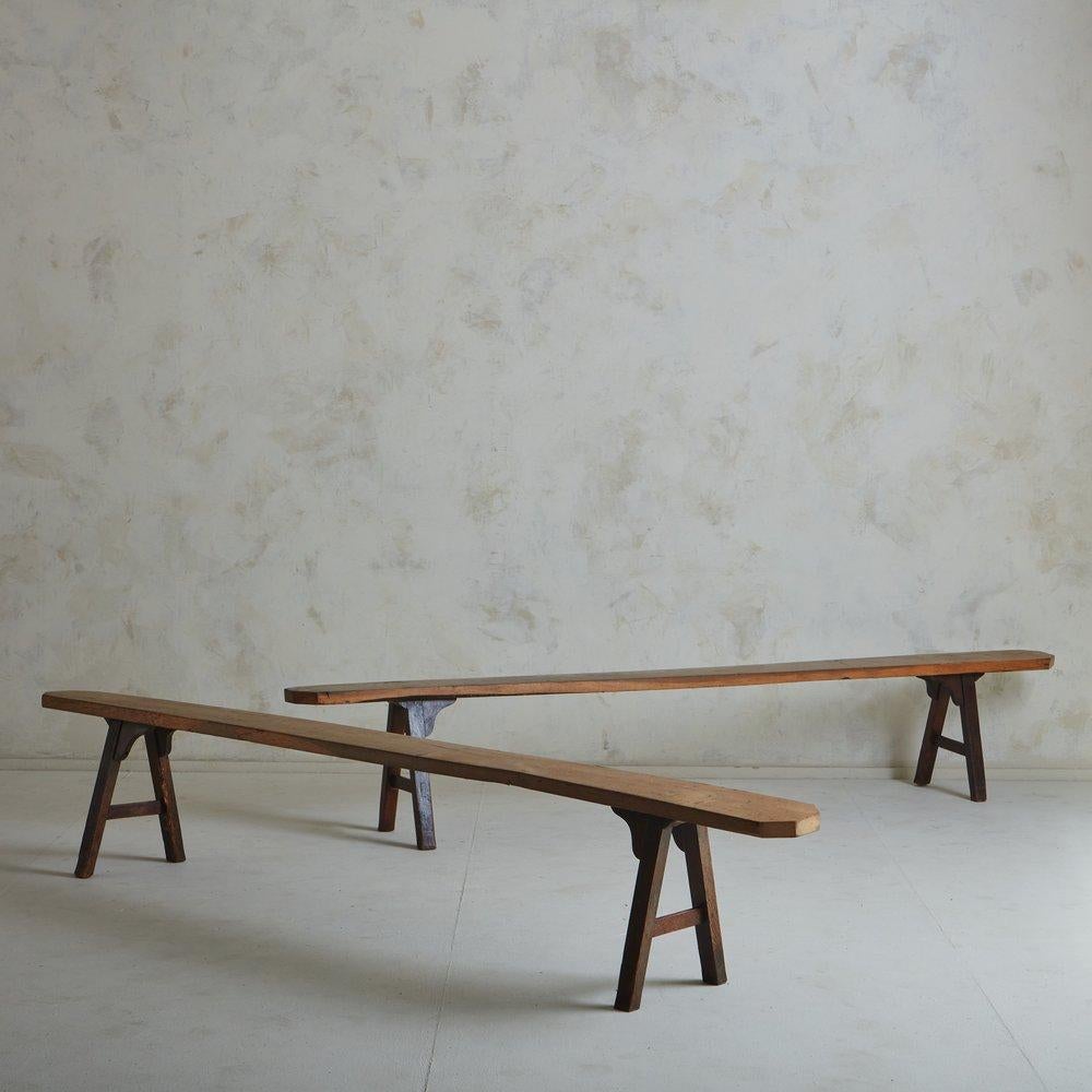 A 1940s French pine wood bench with an elongated seat and trestle legs. Warm, organic and beautifully worn, this bench has incredible character. It displays beautiful craftsmanship with elegant wood joinery. Sourced in France, 1940s. Two available;