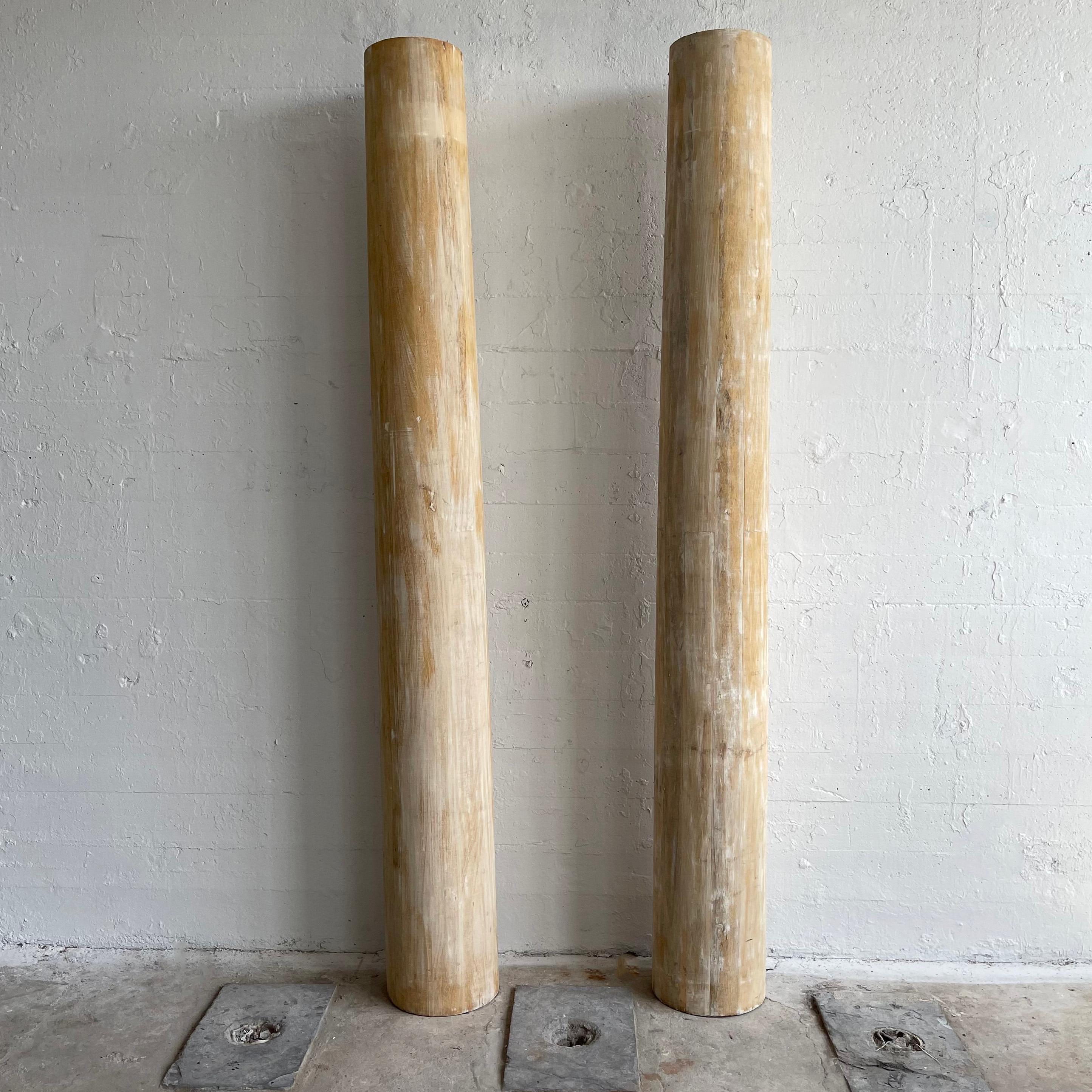 Pair of majestic, architectural columns stand slightly over 8ft tall. The columns are made of hollow poplar and  feature a wonderful, rustic, bark-like patina. They are architectural but not structural.