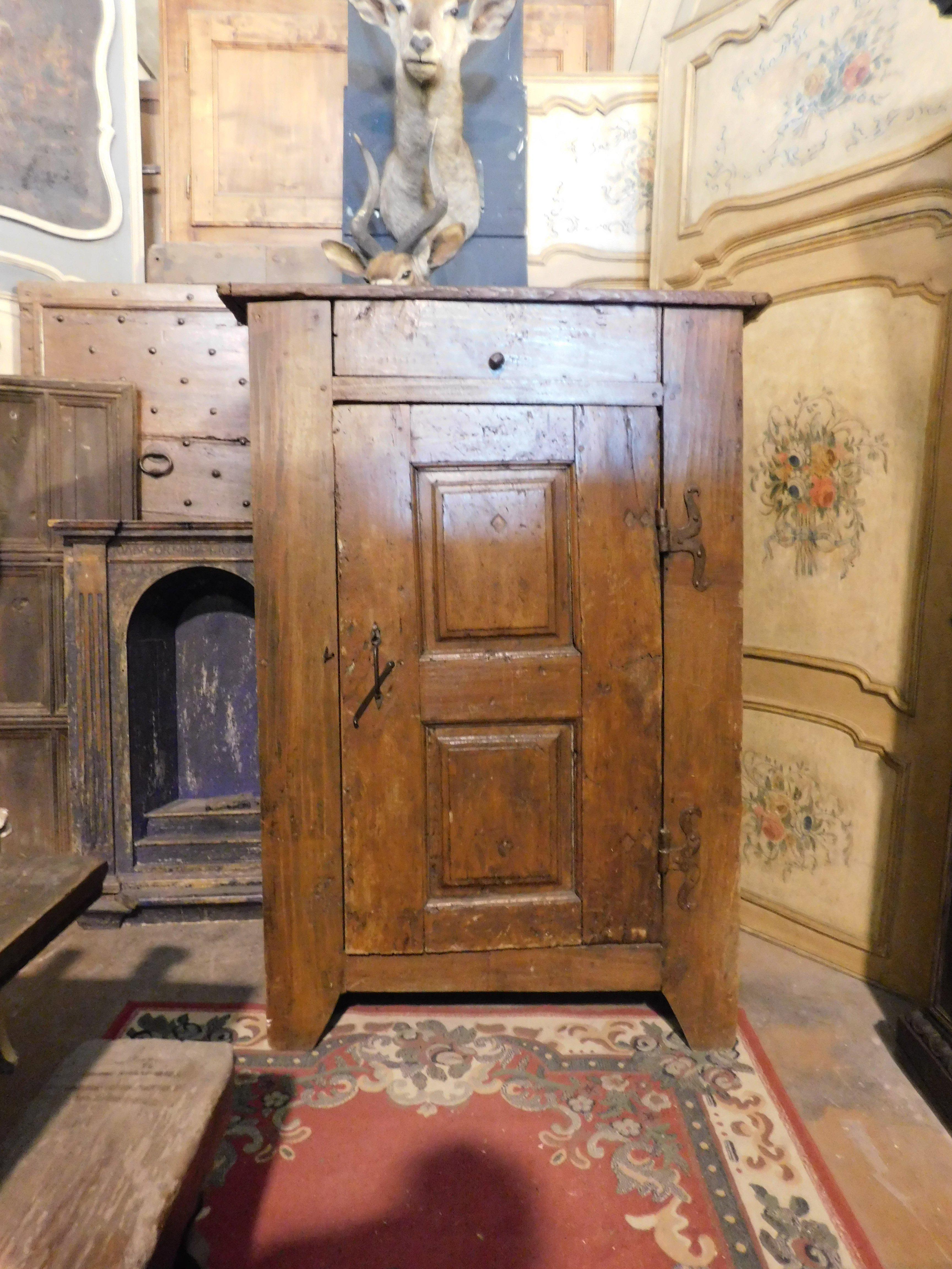 Mueble antiguo, armario o aparador rústico de madera de álamo, con una sola puerta y estante interior, hierros de mariposa originales.
Tiene un falso cajón que se levanta y oculta un compartimento de almacenamiento.
Periodo del siglo XIX, origen: