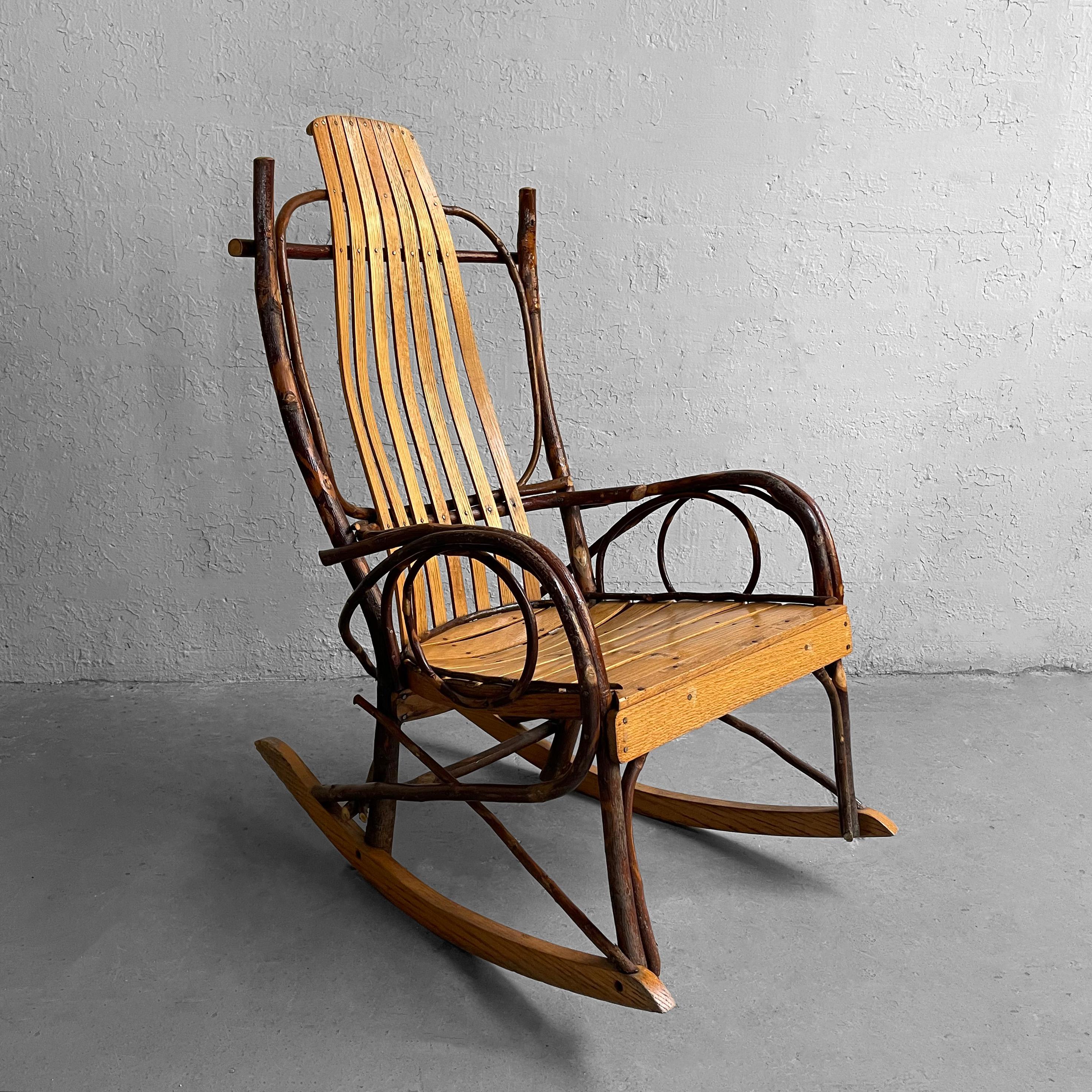 Primitive, Adirondack, craftsman rocking chair features a rustic twig frame with contoured, slat, cherry bentwood seat and high back. Comfy and homey, perfect for a rustic, country decor and can be used on a covered porch. Arm height is 22 inches.
