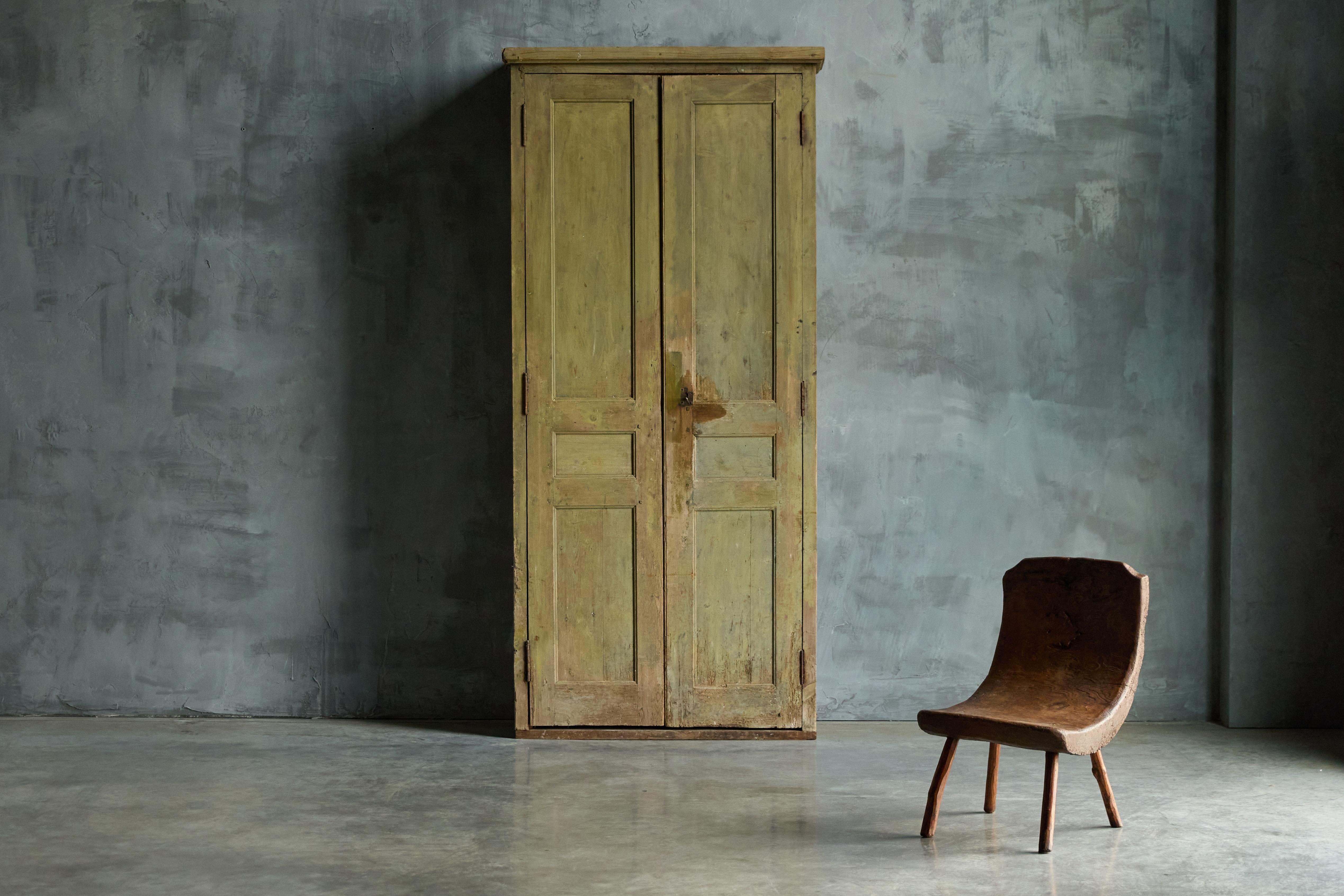 Cette armoire française à deux portes du XIXe siècle est un exemple étonnant de l'artisanat traditionnel. Sa riche patine verte met en valeur son charme rustique et usé par le temps. À l'intérieur, il offre un vaste espace de rangement grâce à des