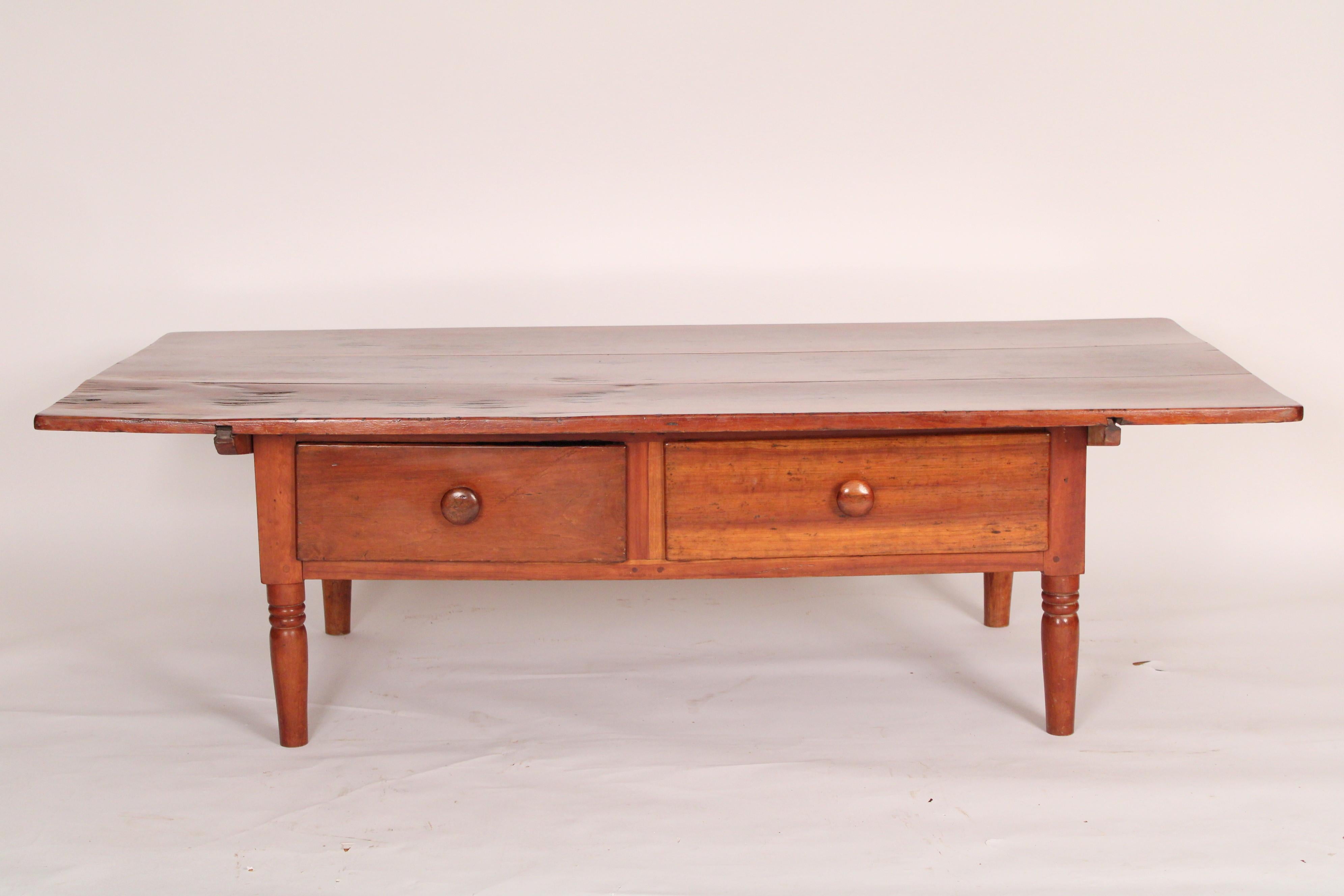 Rustic red pine coffee table, circa 1910. With a rectangular top, two hand dove tailed frieze
drawers, resting on turned tapered legs. Originally this was a kitchen or small dining table that has been reduced in height to be used as a coffee table.