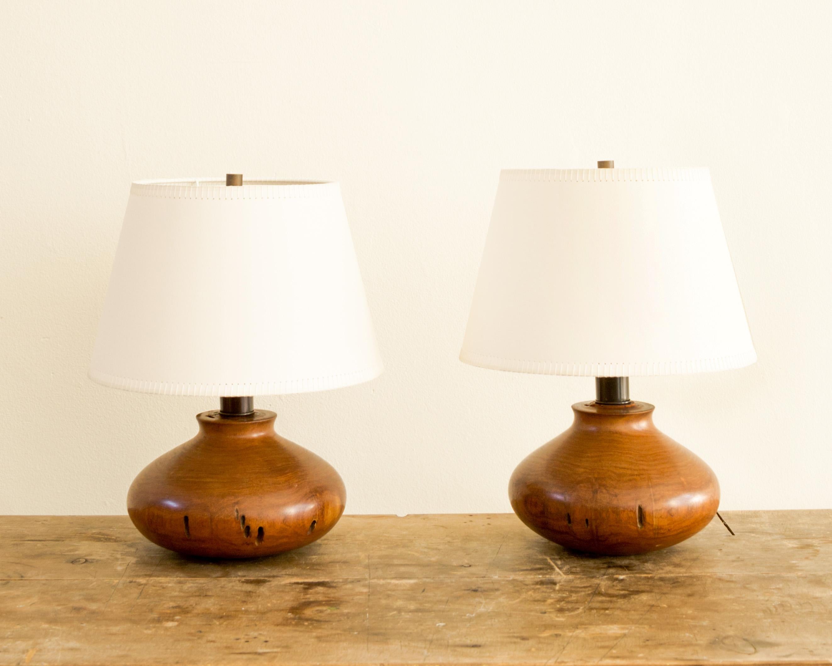 Rustic and refined pair of solid, turned mesquite table lamps, new wiring and new artist paper shades, United States circa 1970's.