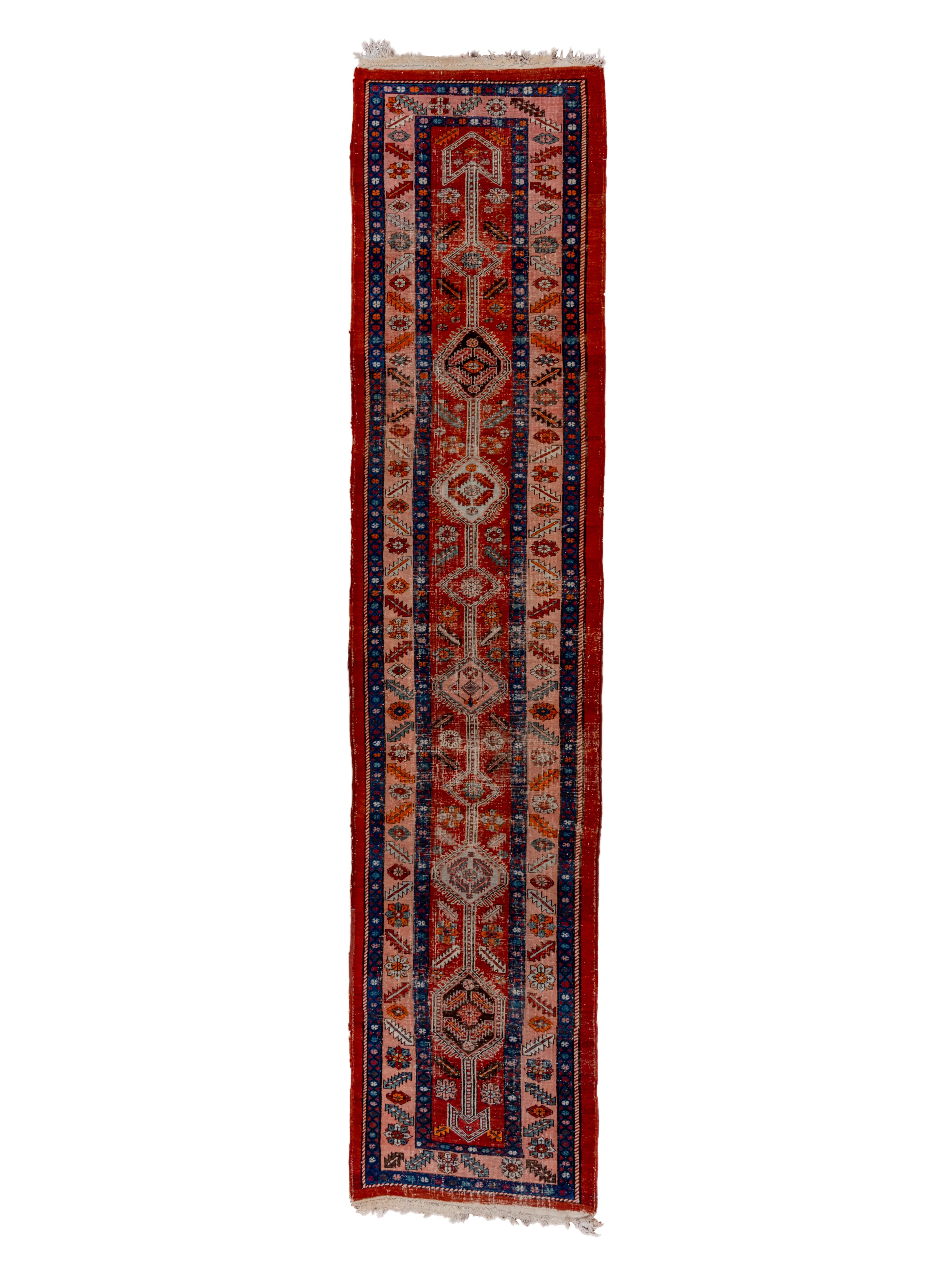 This rustic NW Persian runner from the famous Heriz district features quintapartite pole medallion of uniformly finger fringed hexagons in light blue and straw/camel, with en suite side and corner fillers, all on a narrow madder red ground. All