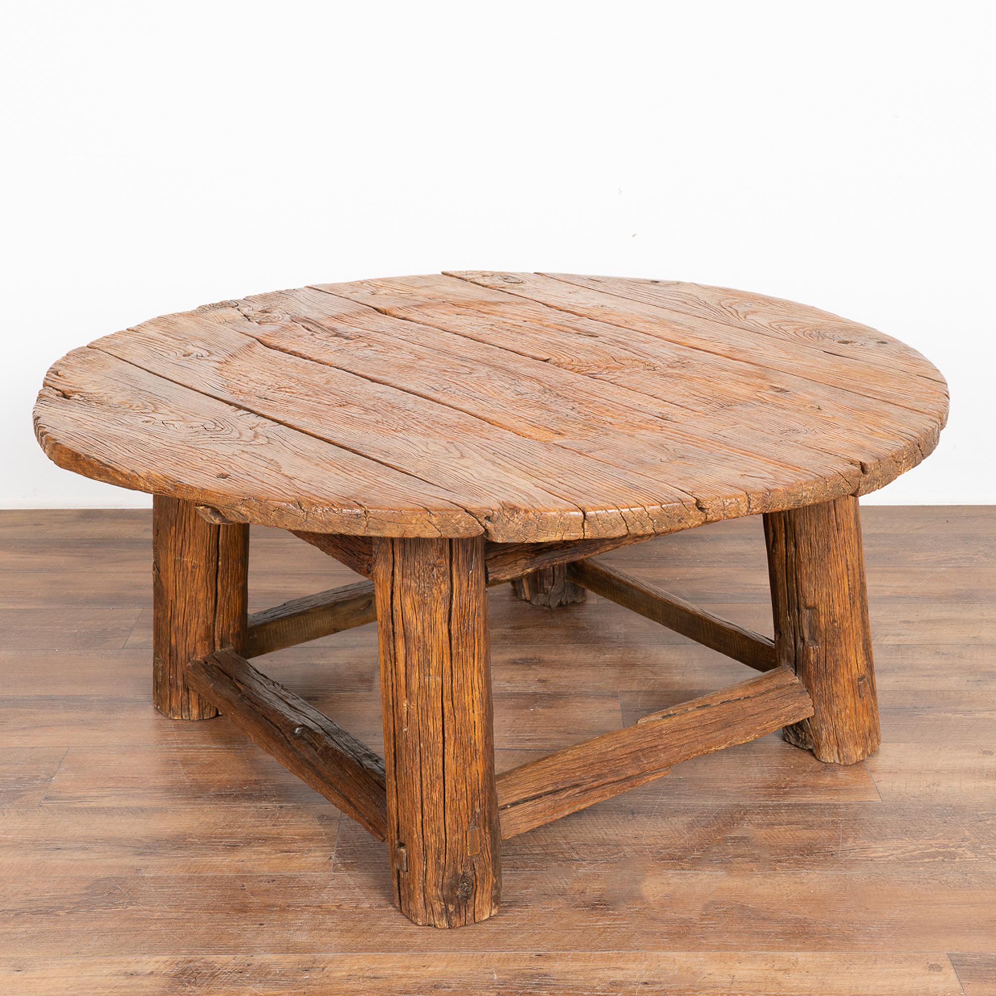 The incredible appeal of this round coffee table comes from the wood itself which is aged, thick and rugged. Every crack, nick and aged-separation add to the depth of character in this rustic table. 
The top along with the heavy rounded legs and
