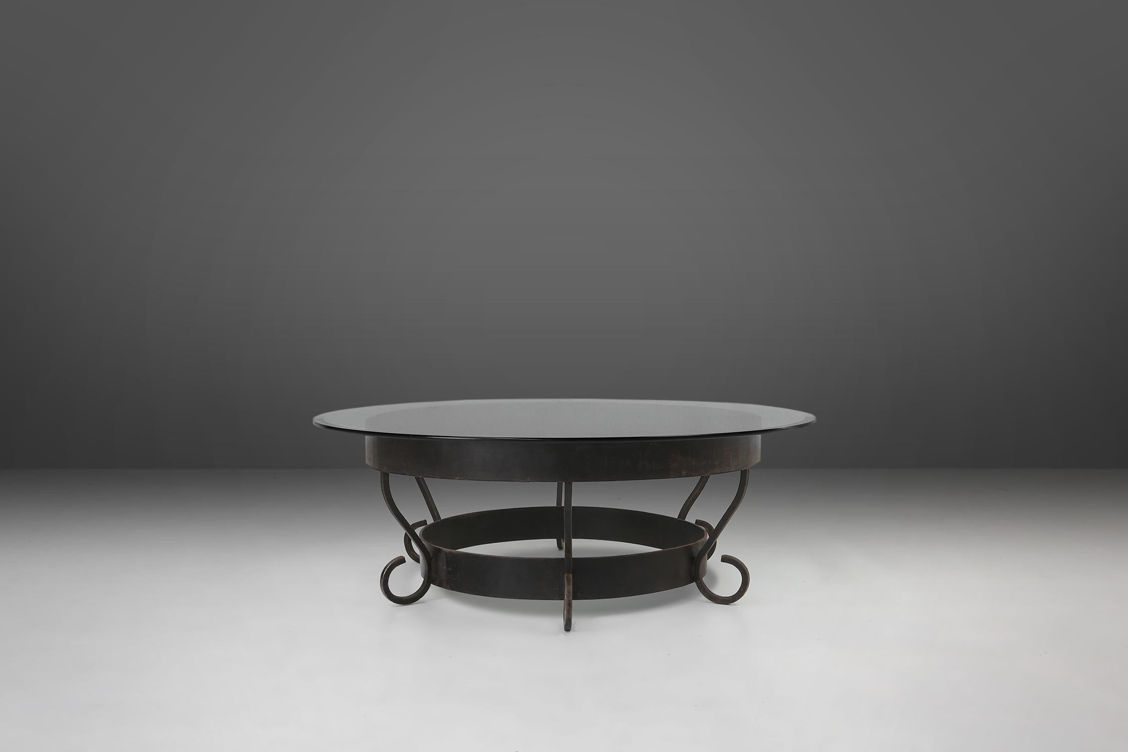 France / 1930s / wrought iron and glass / rustic / mid-century / industrial

Large rustic round French coffee table with wrought iron base and a round glass top with nice patina. The intricate metal base has delicate curves and elegant detailing