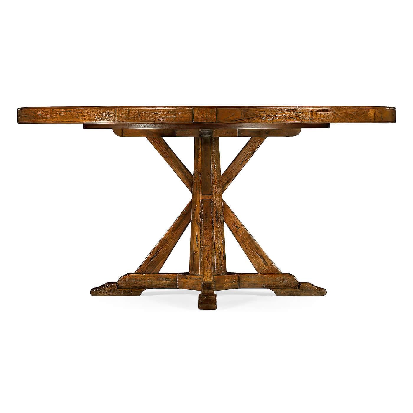 Der runde Esstisch ist in einem warmen Nussbaumfarbton gehalten, hat ein rustikales Finish mit sichtbaren Sägespuren und steht auf einem Sockel im Landhausstil. Der Tisch verfügt außerdem über eine eingebaute, selbstaufbewahrende