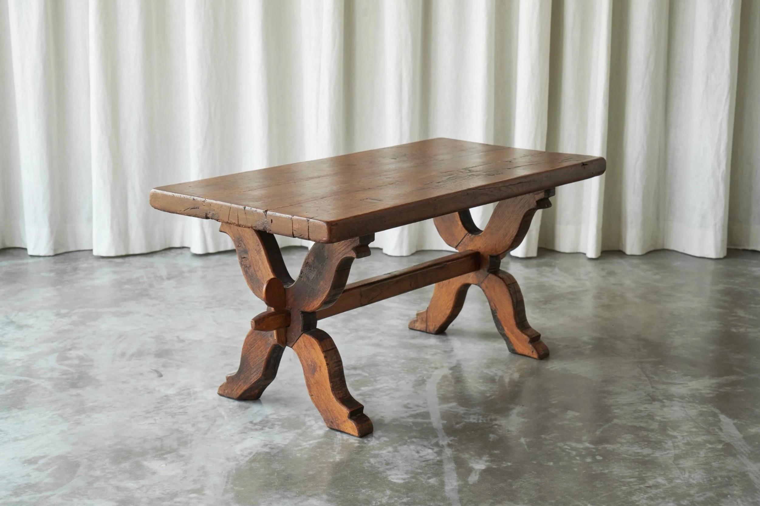 Rustic Trestle Coffee Table in Solid Oak, Late 19th Century.

This solid oak coffee table with very decorative trestle legs comes from the late 19th century is a robust and charming piece.

The tabletop is thick and substantial, featuring visible