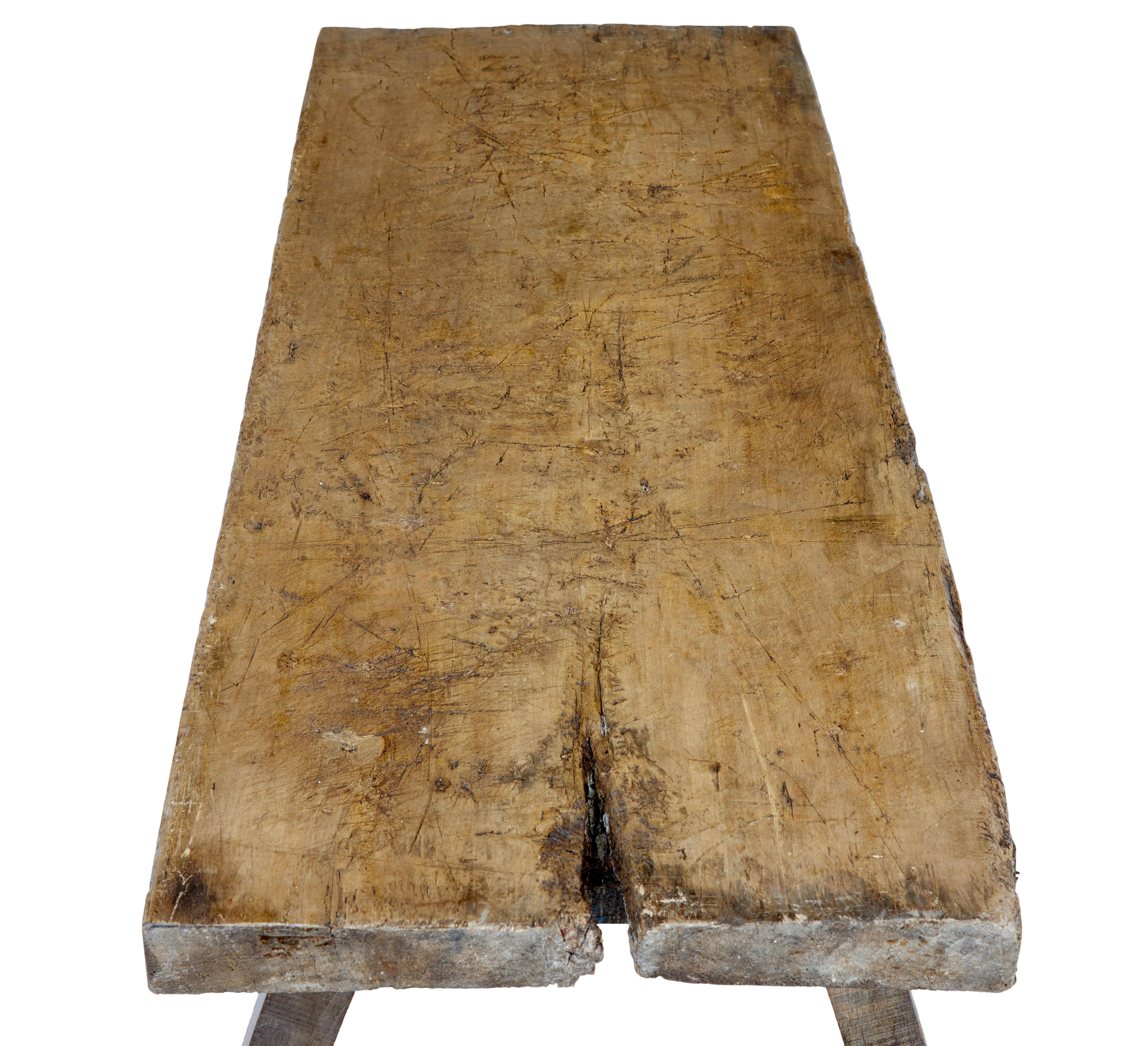 Rustic 19th century elm bench circa 1860.

Known as a pig bench, this bench made from 1 solid piece of elm offers and excellent opportunity to work as a coffee table.

Rectangular top with natural form of the tree left on 1 end.  Standing on 4
