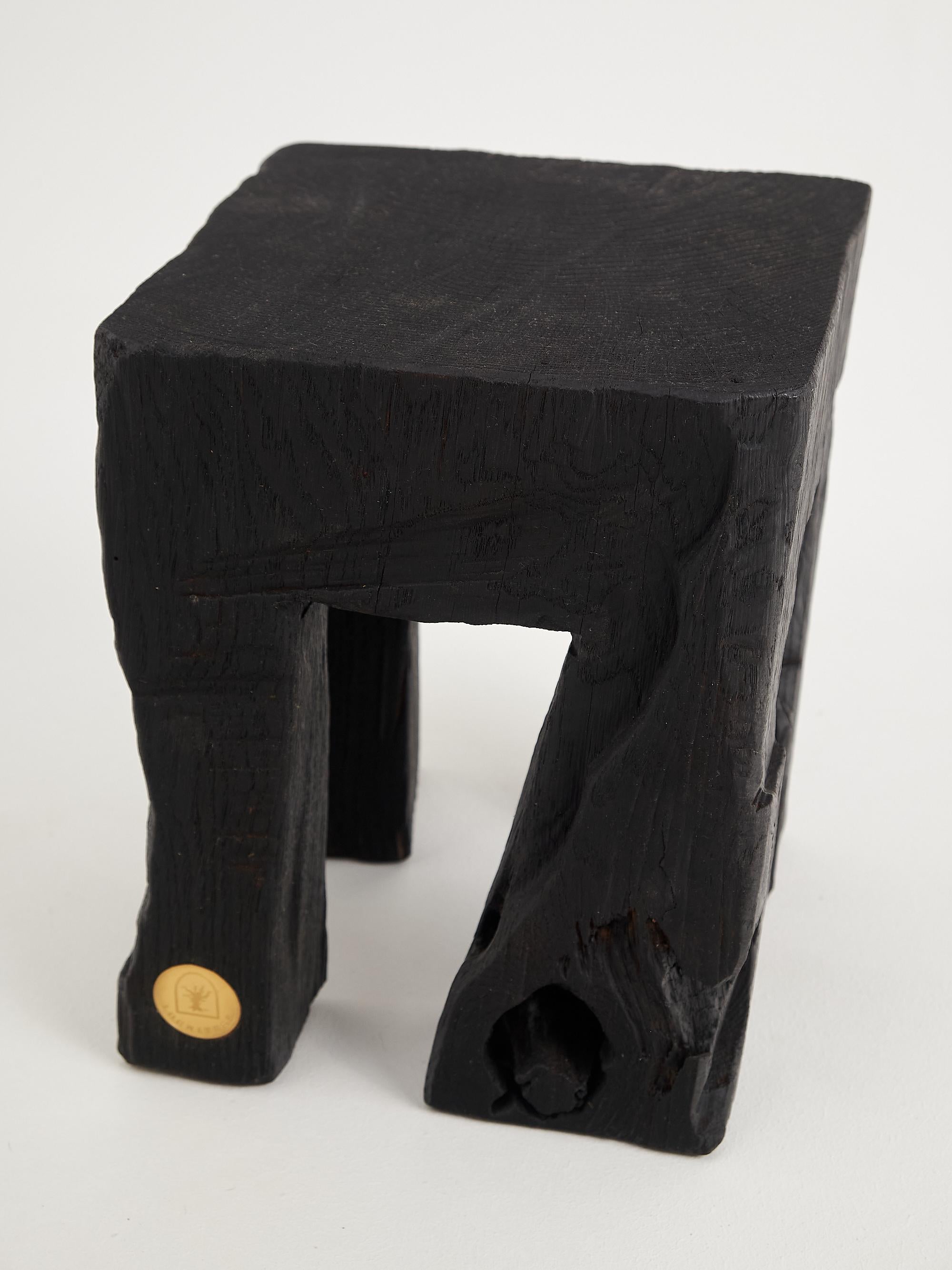 Mesa/taburete auxiliar tallado con motosierra. Tallada en una sola pieza de madera de roble quemada y protegida con aceites de la máxima calidad, lo que garantiza su durabilidad durante generaciones. Este diseño único hecho a mano realzará su