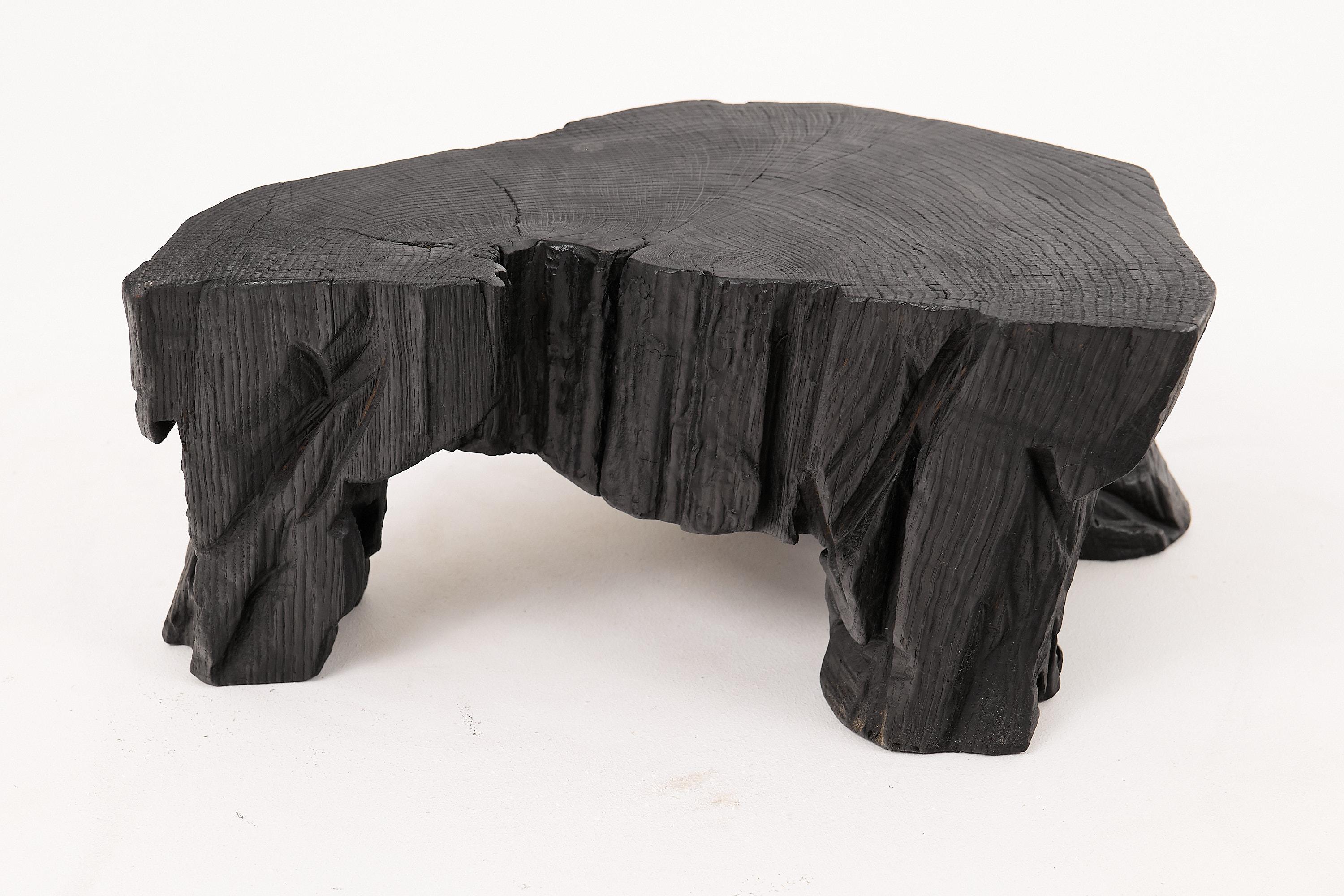 Mesa/taburete auxiliar tallado con motosierra. Tallada en una sola pieza de madera de roble quemada y protegida con aceites de la máxima calidad, lo que garantiza su durabilidad durante generaciones. Este diseño único hecho a mano realzará su