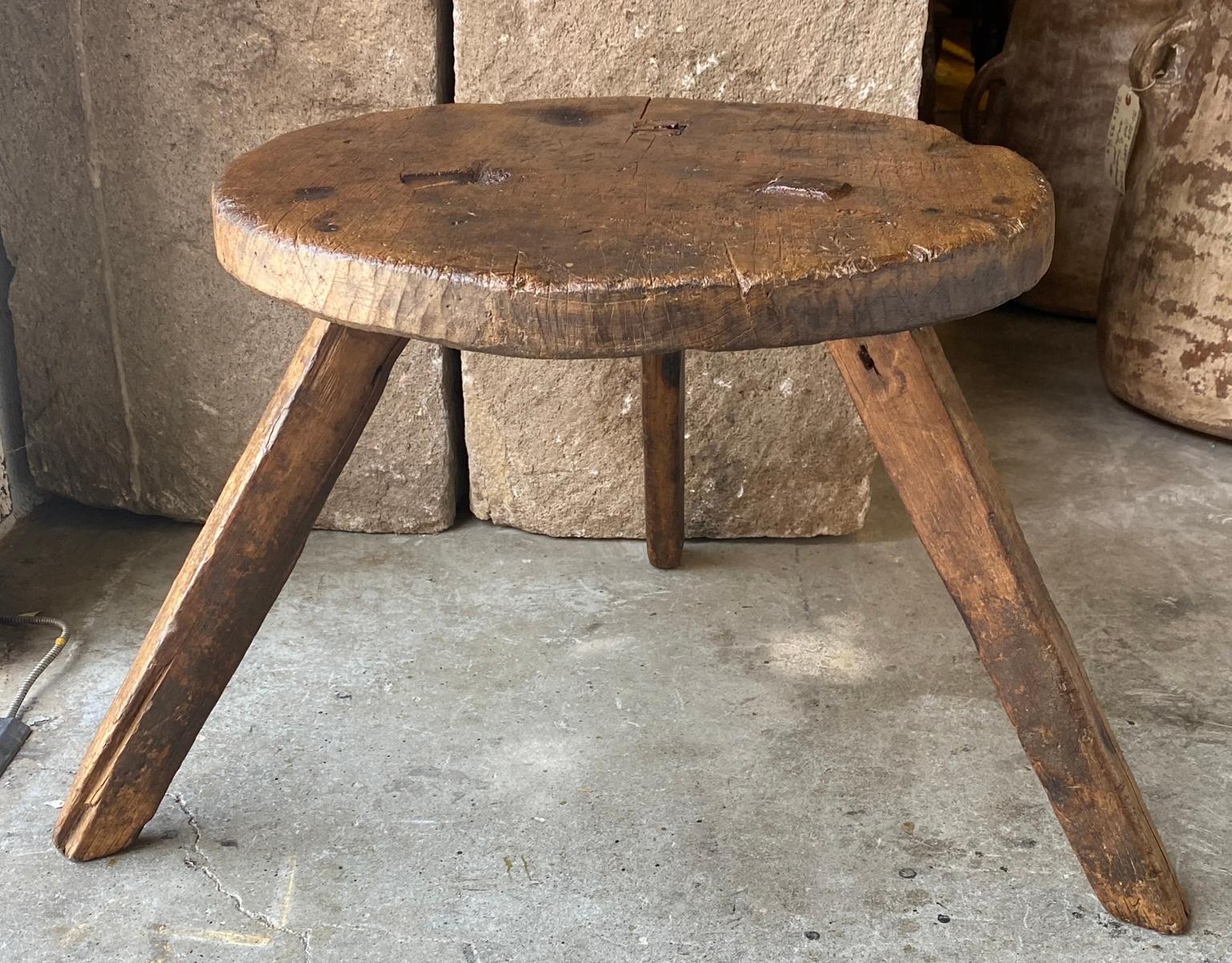 This piece can be used as side table or stool. Footprint of legs is a 25.5 triangle.
The round top shows signs of being used as a candle stand, hence the old burn marks, which add to the soft patina. Easy to pick up and move around where ever you