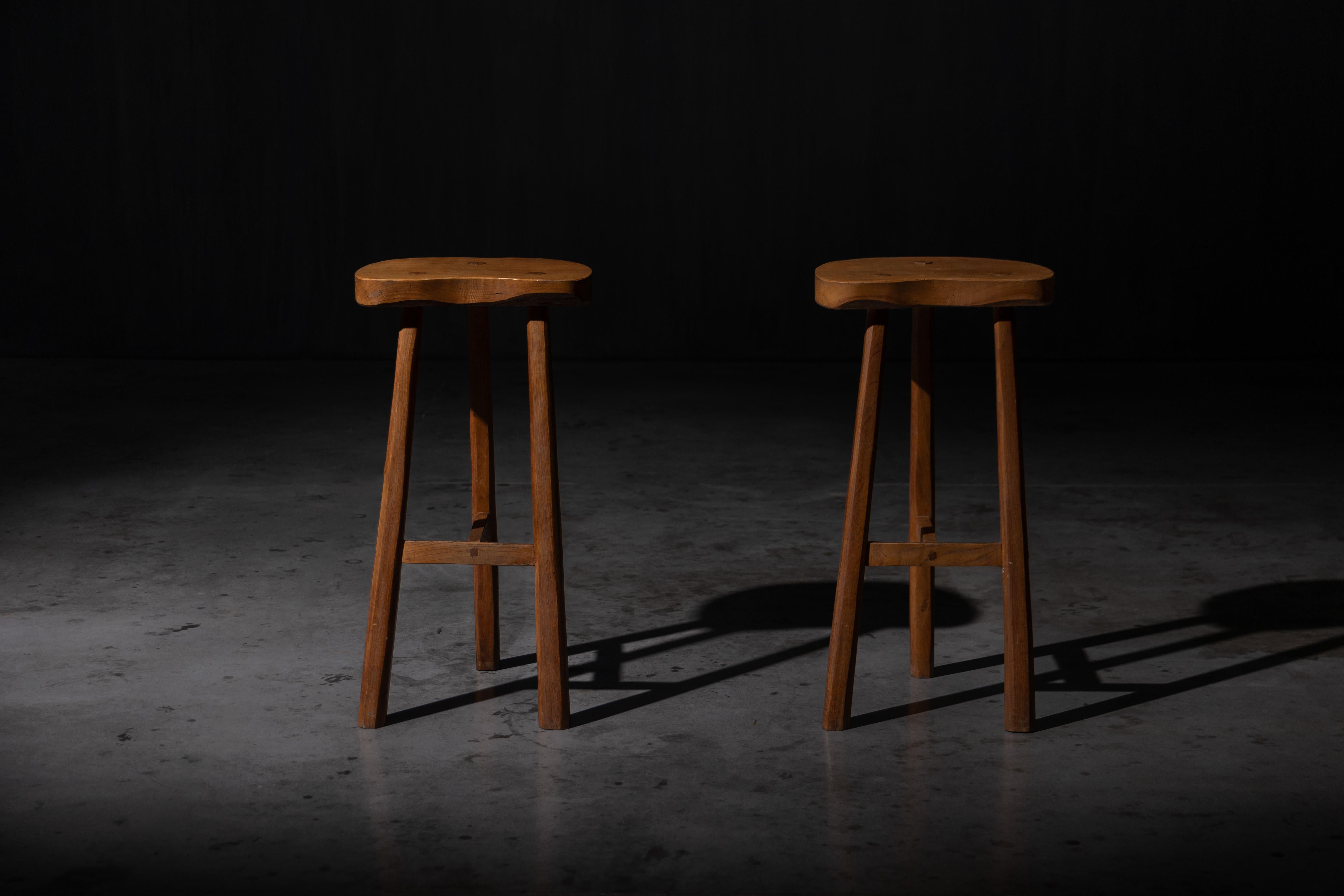 Beautifully handcrafted rustic bar stools, made from solid wood with a warm, natural finish. Each stool features a uniquely contoured seat that showcases the natural grain and texture of the wood. These stools are perfect for kitchens, home bars, or