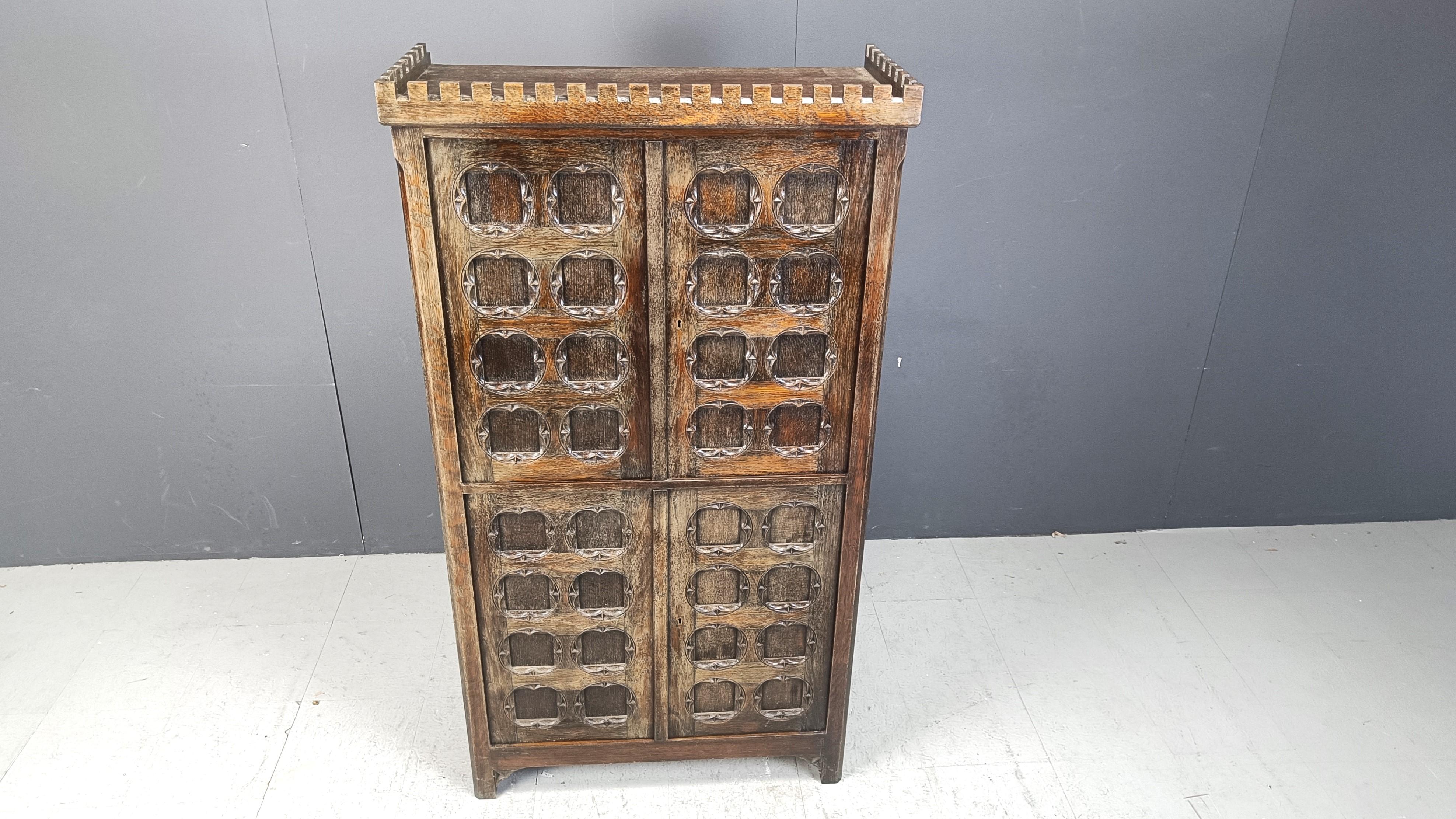 Rustic Spanish 'brutalist style' cabinet.

Graphical panel doors reveal an upper storage space with shelves and a lower part with mulitple drawers.

Good looking, rustic piece of furniture which makes us think of a castle, thanks to the details on