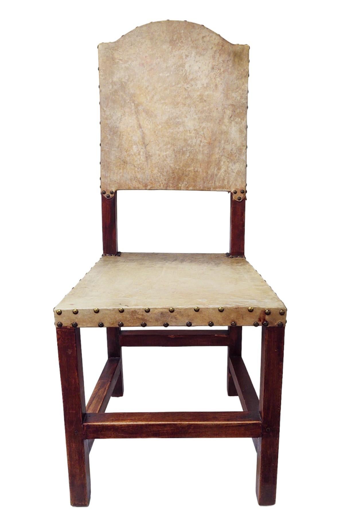 Cette chaise d'appoint ou de salle à manger robuste et rustique est dotée d'un cadre en bois robuste à la finition profonde et chaleureuse. Elle présente des lignes simples et rectilignes, renforcées par des supports en forme de brancards. Le