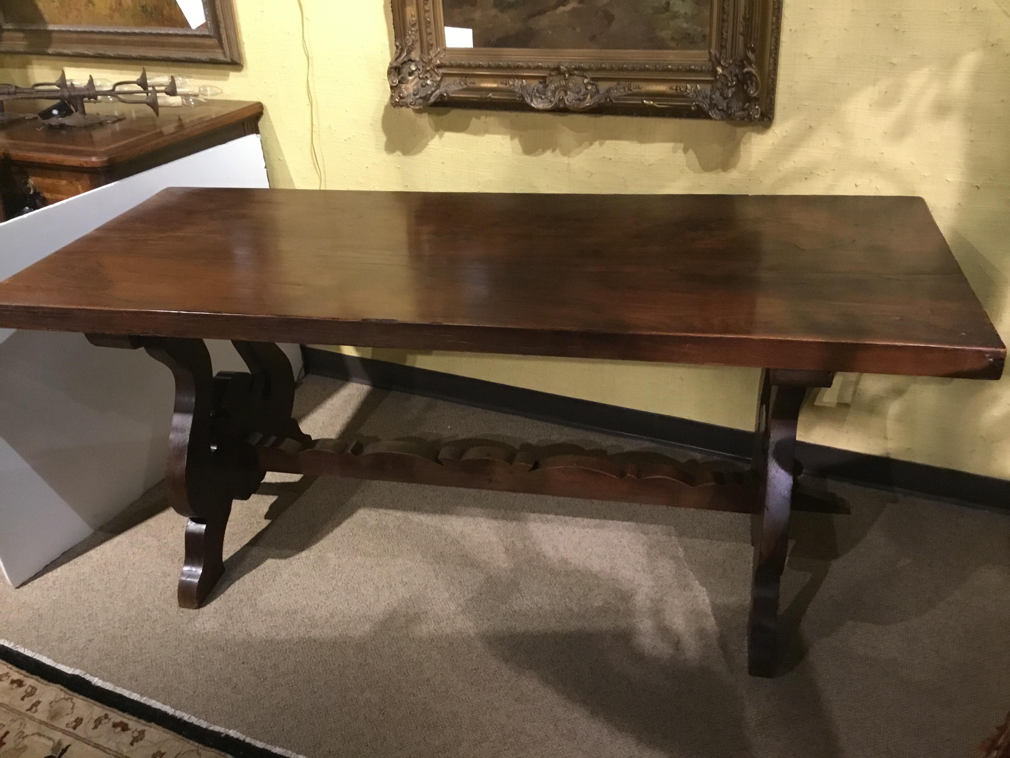 Handsome with a rustic quality. Very thick wooden top supported by ox bow shaped ends.
A carved stretcher with scalloped carving makes this table both sturdy and attractive.
Great piece for a ranch or cabin or any rustic home.