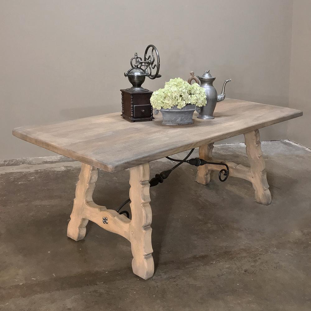 Rustic Spanish stripped oak dining table was painstakingly crafted from solid, thick planks of dense quarter-sawn oak, then band-sawn on the legs for a classic Mediterranean touch. Forged iron stretchers connect the planks of the top to the legs for