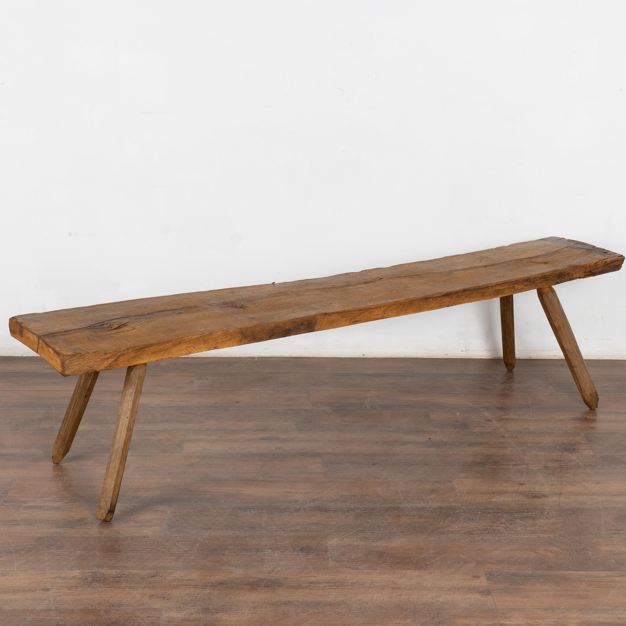 Rustic 6.5' long plank top bench with splay peg legs.
The top reveals generations of use with cracks, nicks, and stains which add character to the narrow bench.
Restored and waxed, this bench is strong, stable and ready for use. 
All scratches,