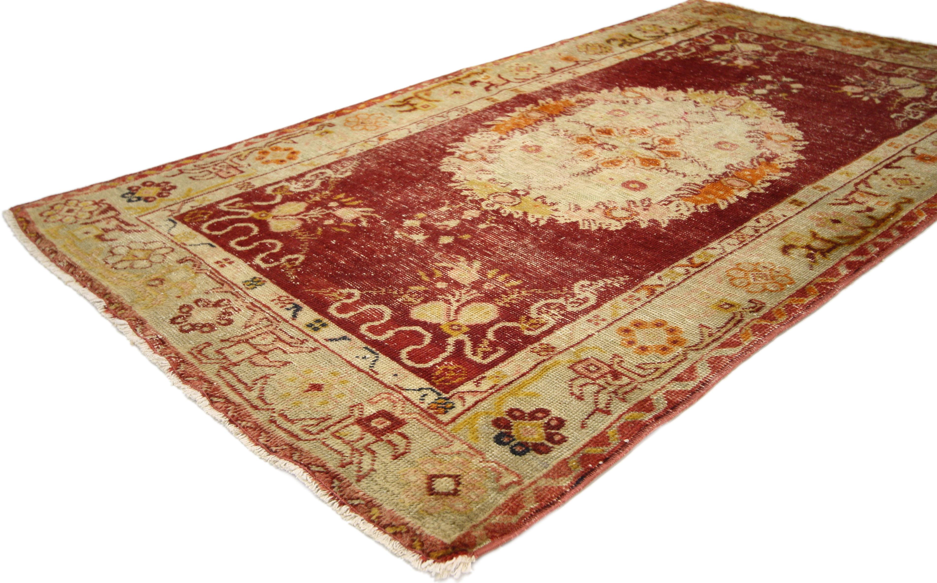 52343, rustic style distressed vintage Turkish Oushak rug. This hand knotted wool vintage Turkish Oushak rug features a large floral oval centre medallion with vase pendants across an abrashed scarlet red field. Delicate cloud bands accentuate the