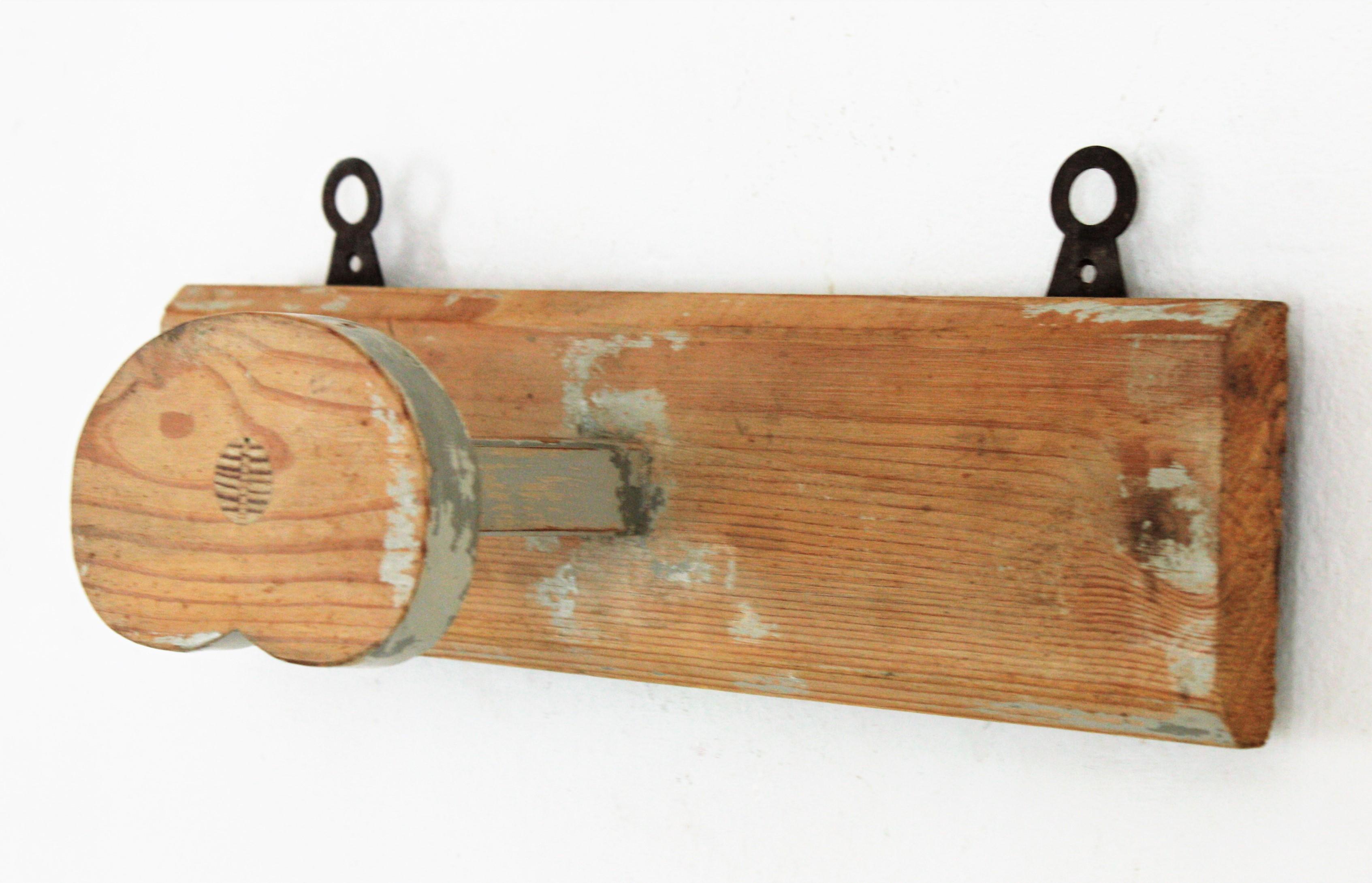 Lovely rustic wooden wall hanger with gray patinated accents, Spain, 1930s.
This stylish wall coat hanger comes from a farmhouse at the Catalan Costa Brava. It is made in pine wood with a single heart shaped hanger and 2 visible iron holders. It