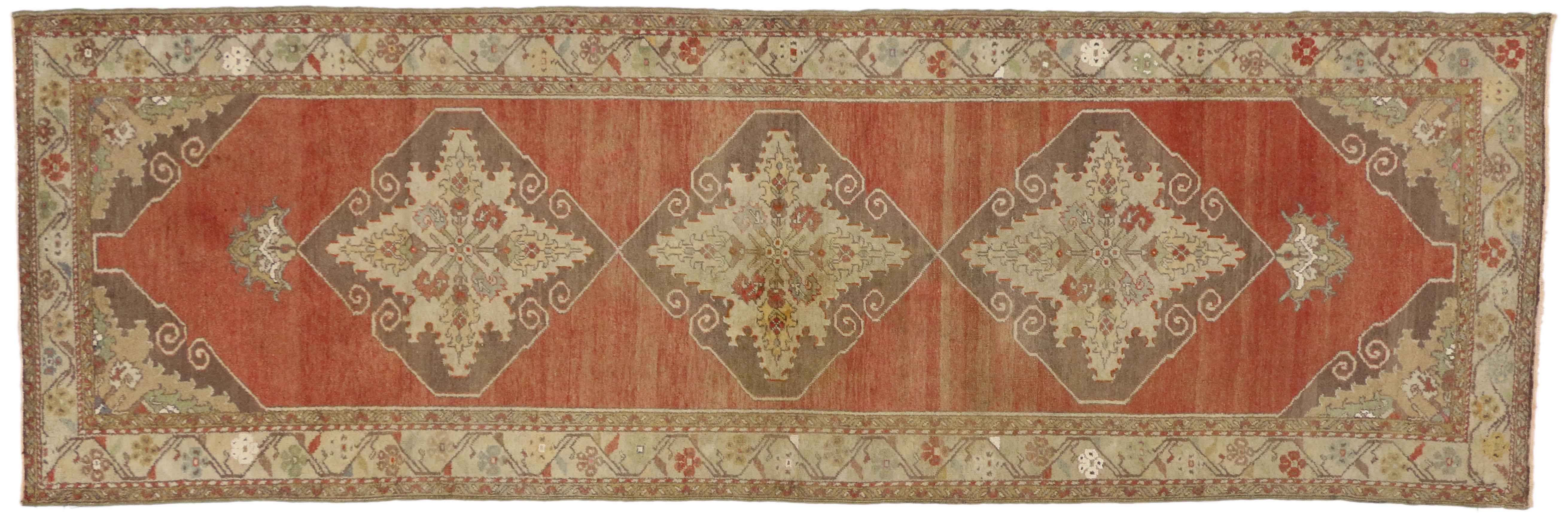 50646, vintage Turkish Oushak runner, hallway runner. This hand knotted wool vintage Turkish Oushak runner features three connected hexagonal medallions with interior palmette and lanceolate leaf designs and palmette pendants across an abrashed