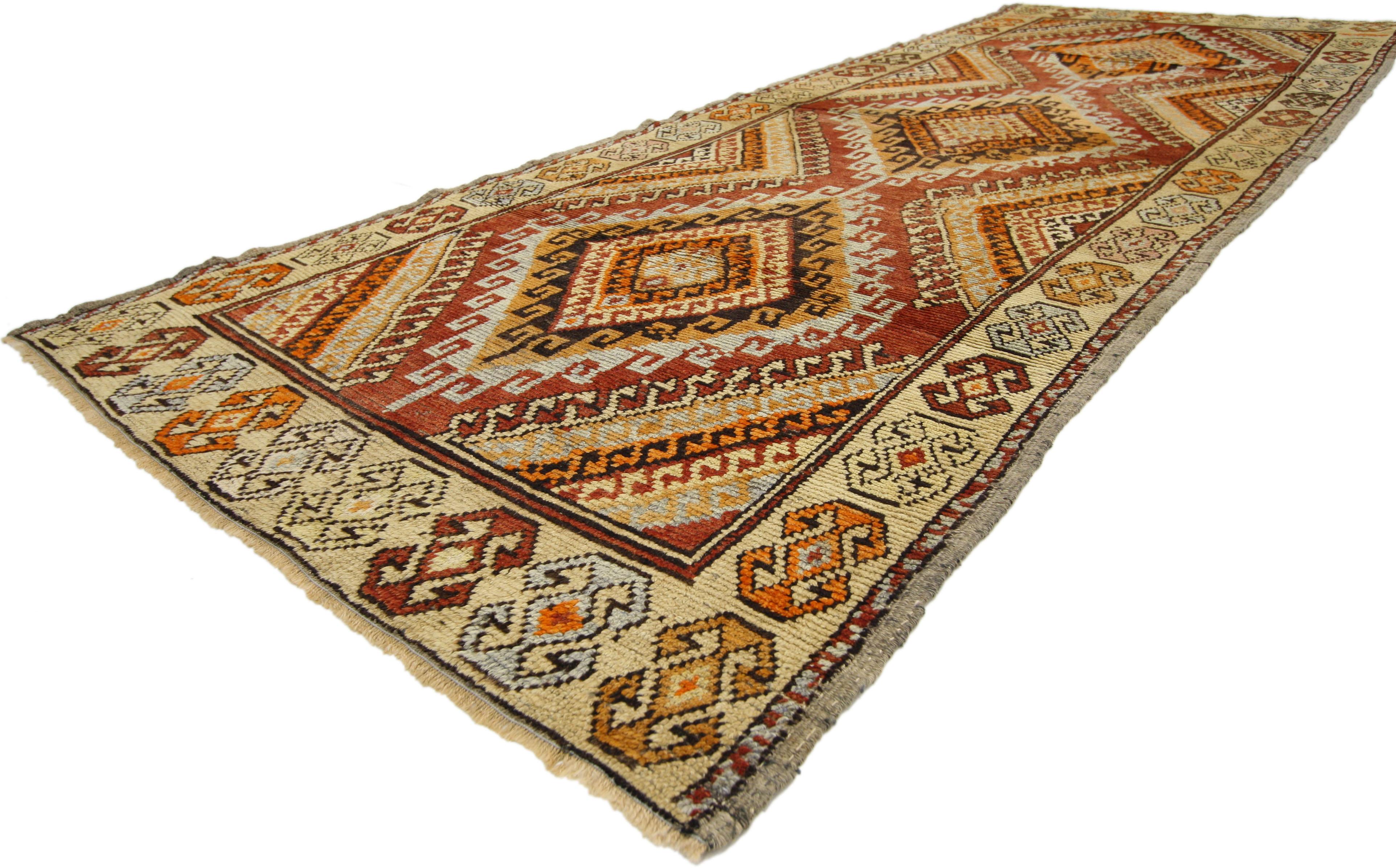 50358 Rustic style vintage Turkish Oushak Carpet Runner with Modern Tribal Design. This hand-knotted wool vintage Turkish Oushak runner features three stacked lozenge medallions with latch hook edges and steep latch hooked ziggurats protruding